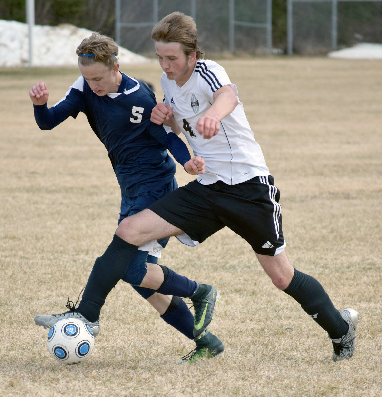 Soldotna’s Luke Trammell and Nikiski’s Michael Eiter try and shoulder each other off the ball Monday, May 18, 2017, at Nikiski High School. (Photo by Jeff Helminiak/Peninsula Clarion)