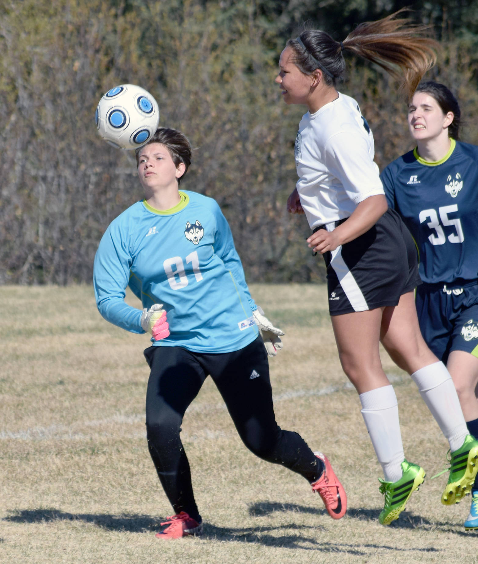 Nikiski’s Deidra Lamping heads the ball wide of the goal as Redington goalie Grace Rushing and defender Courtney Crocket look on Friday, May 12, 2017, at Nikiski High School. (Photo by Jeff Helminiak/Peninsula Clarion)