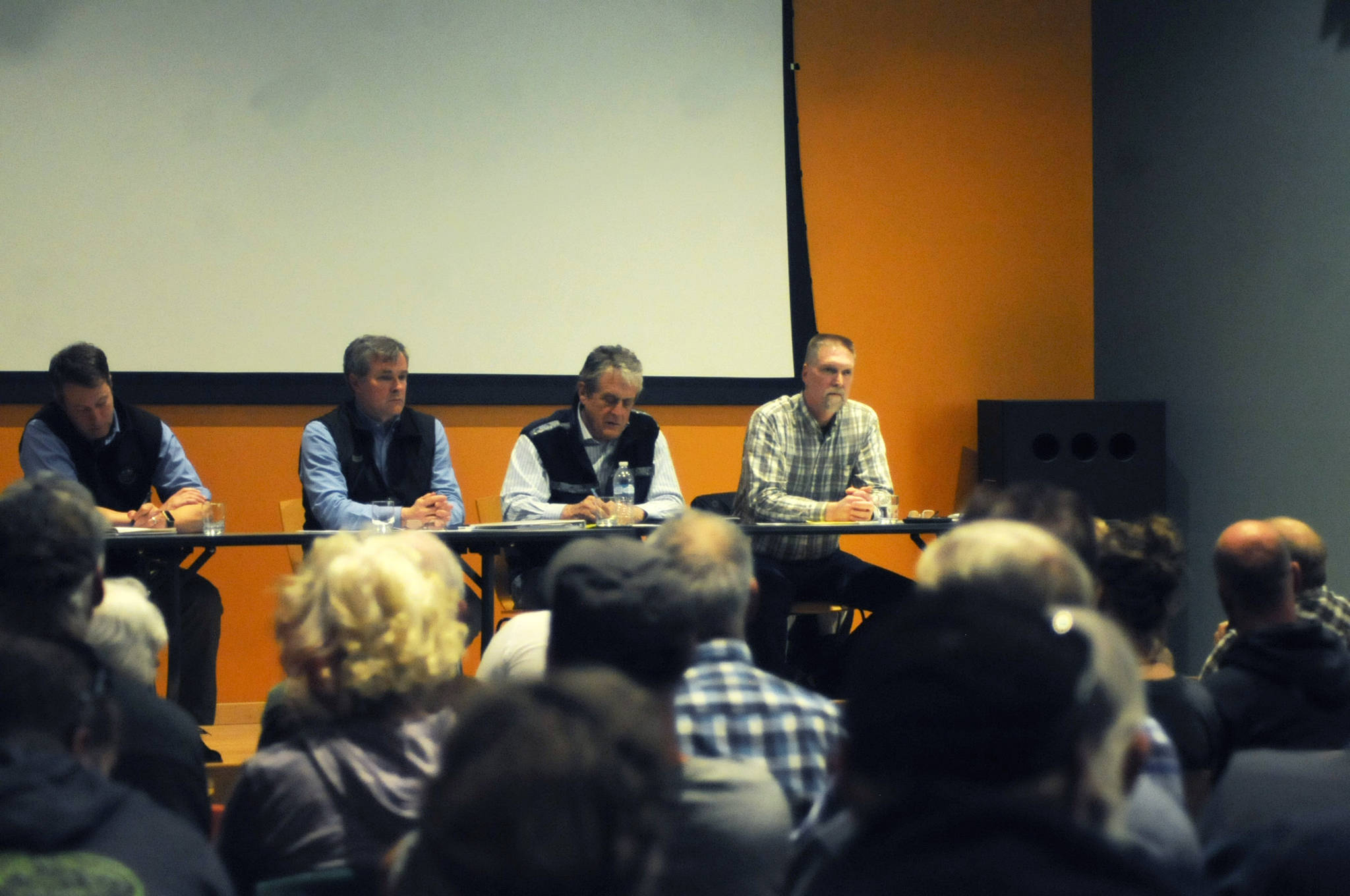 From right, Alaska Department of Fish and Game geneticist Sam Rabung, Fish and Game Commissioner Sam Cotten, Alaska Department of Natural Resources Commissioner Andy Mack and Division of Parks and Outdoor Recreation Acting Director Matt Weideke listen to concerns from Homer and Tutka Bay residents about a permit that would authorize Cook Inlet Aquaculture Association to move its net pens in Tutka Bay from the lagoon to the head of the bay at a meeting at the Islands and Ocean Visitor Center on May 15 in Homer. (Photo/Elizabeth Earl/Peninsula Clarion)