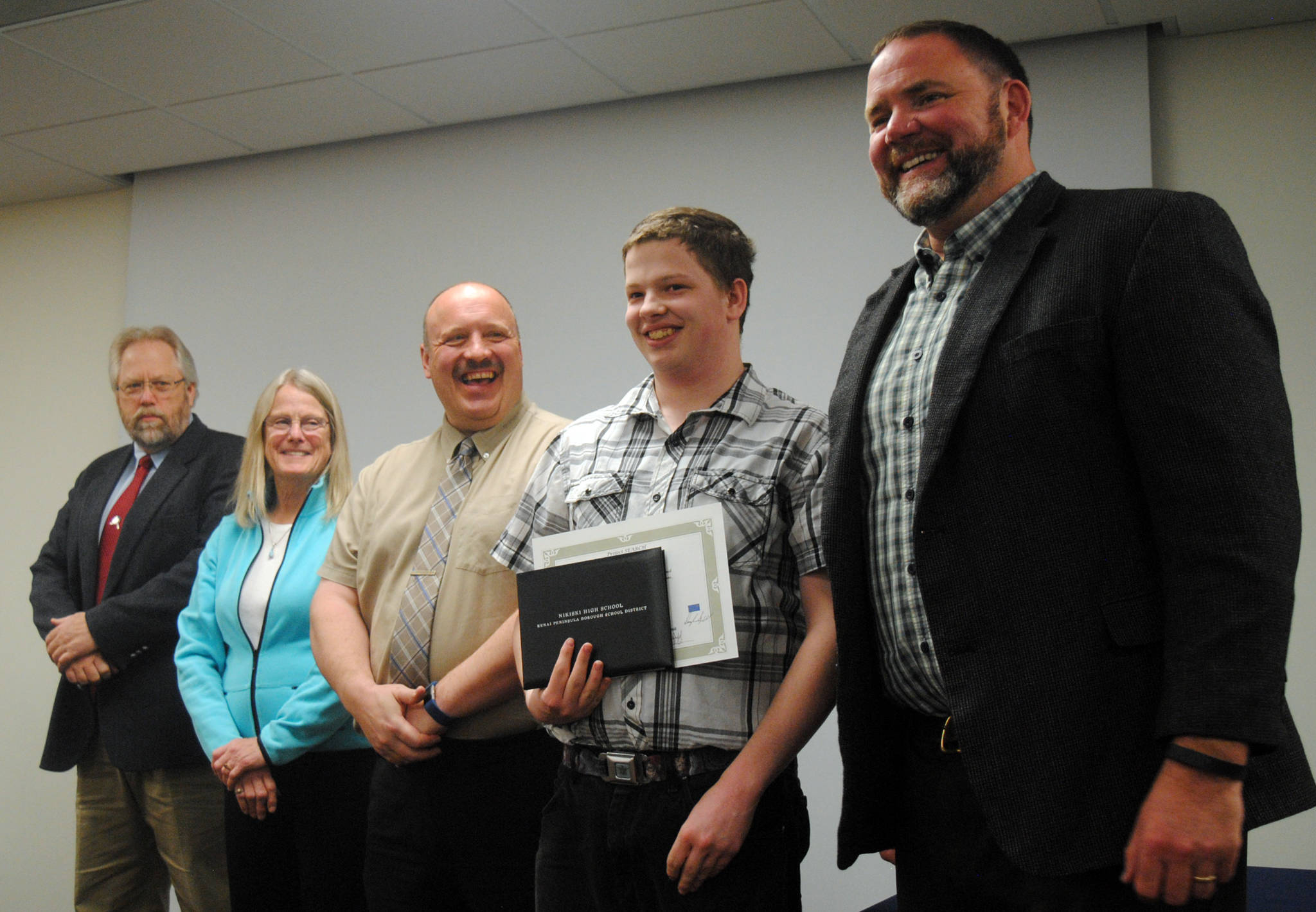 Nikiski High School student Justin Mason, with diploma, poses for a photo at his graduation from Project SEARCH flanked by (left from right) Kenai Peninsula Borough School District Assistant Superintendent Dave Jones, Board of Education member Penny Vadla, Superintendent Sean Dusek and Pupil Services Director Clayton Holland, Monday, May 16, 2017 at Central Peninsula Hospital. (Kat Sorensen/Peninsula Clarion)