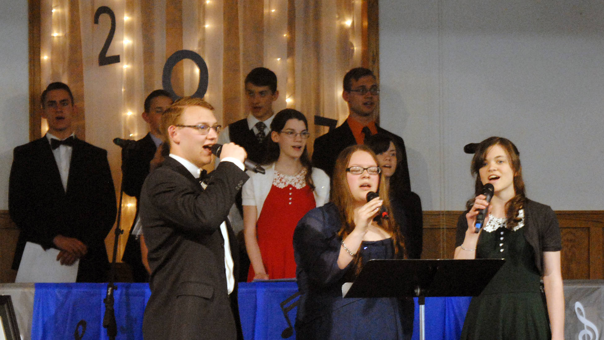Elijah Newbern, left, Ellimarie Bravo-Moe and Shelby Noel sing “I Have Been Blessed” at their graduation ceremony on Friday, May 19, 2017 at the Immanuel Baptist Church in Kenai, Alaska. Newbern and Bravo-Moe are graduates of the Wings Christian Academy. Noel is a home school graduate. (Kat Sorensen/Peninsula Clarion)