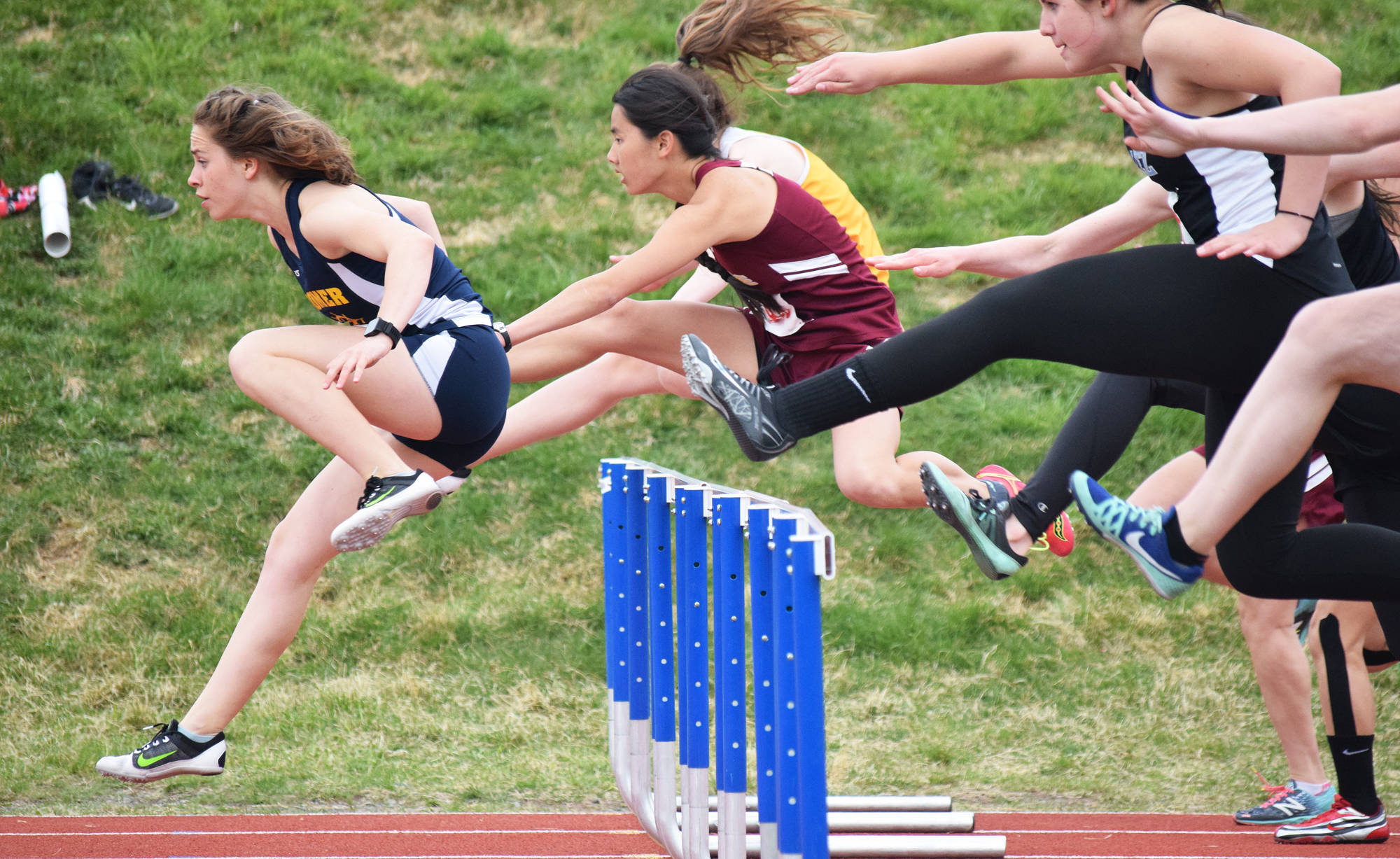 Homer’s Lauren Evarts (far left) leads the field over the first barrier in the Class 3A girls 100-meter hurdles final Saturday at the Region III track & field championships in Homer. (Photo by Joey Klecka/Peninsula Clarion)