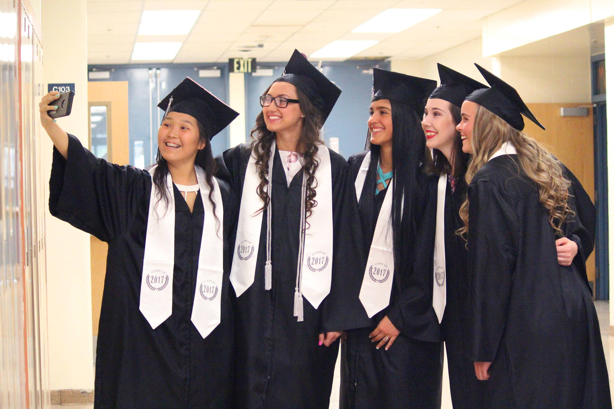From left to right: Desmeranda Napoka, Ayla Pitt, Brianna Vollertsen, Madison Williams and Sofie Nielsen pose for a quick picture before walking in their graduation ceremony Tuesday, May 23, 2017 at Nikiski Middle-High School in Nikiski, Alaska. (Megan Pacer/Peninsula Clarion)