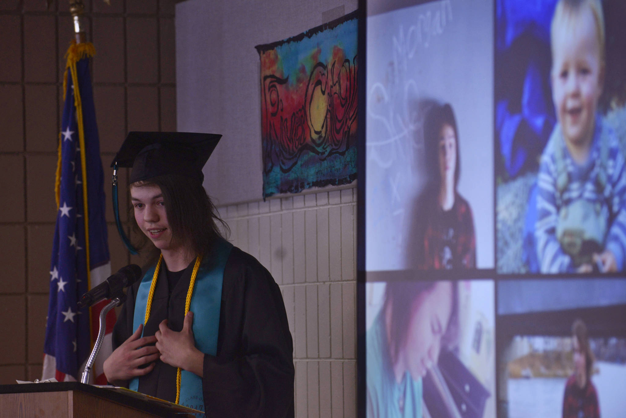 Flanked by his past portraits, River City Academy graduate Morgan Shepherd speaks to his eleven peers in River City’s class of 2017 during the school’s graduation ceremony on Wednesday, May 24, 2017 at the Soldotna Regional Sports Complex in Soldotna, Alaska. All the graduates gave speeches at the ceremony, introduced by principal Dawn Edwards-Smith, who compared each one to a literary or cinematic hero.