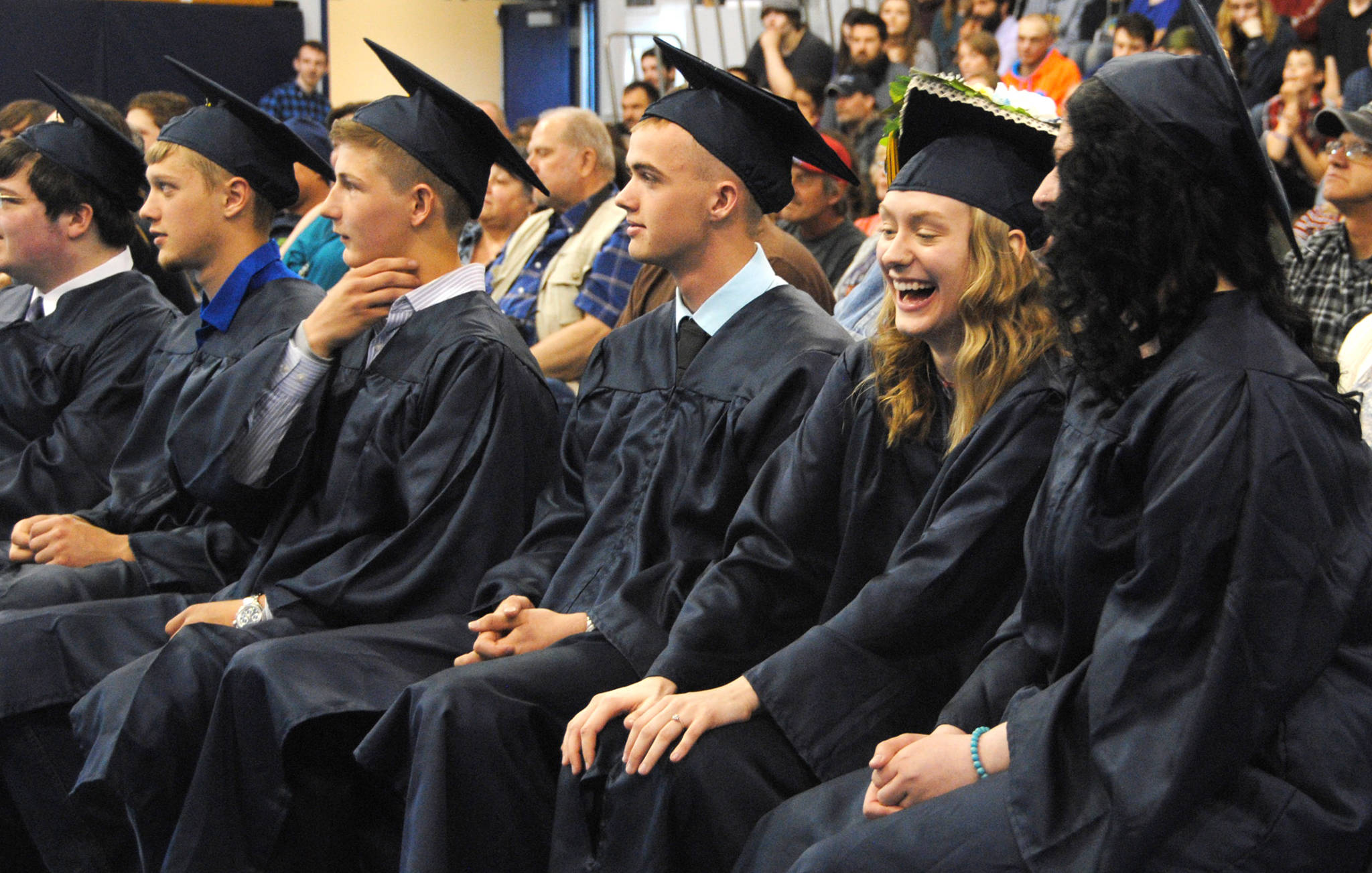 Tatiana Cooper, laughing, of Ninilchik's graduating class reacts to Barbara Denboer's commencement address during the graduation ceremony on May 24, 2017 in the Ninilchik School Gym in Ninilchik, Alaska. (Kat Sorensen/Peninsula Clarion)