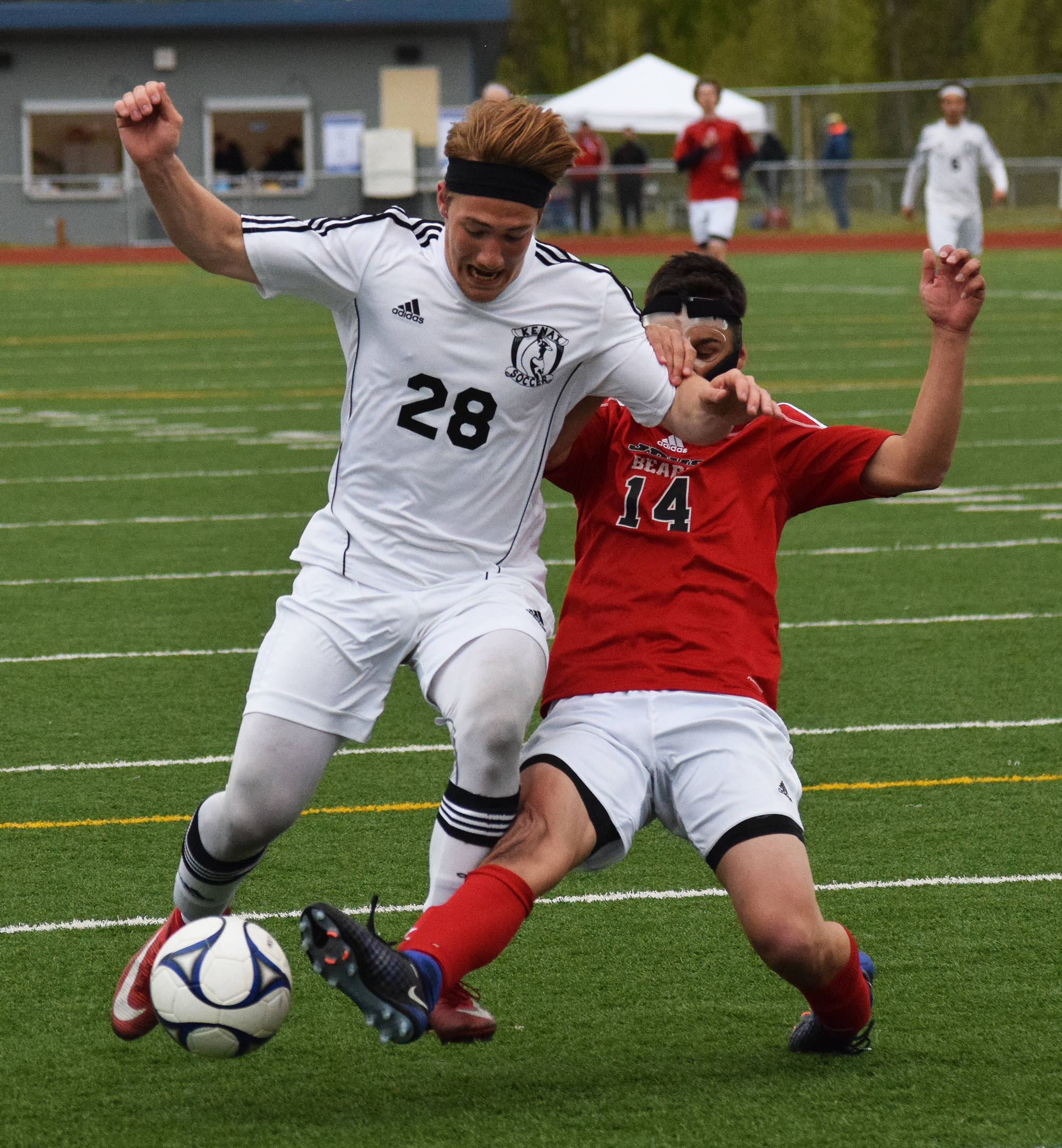 Kenai Central’s Rykker Riddall (28) and Juneau-Douglas’ Ben Undurraga battle for possession in a quarterfinal meeting Thursday at the state soccer tournament at Eagle River High School. (Photo by Joey Klecka/Peninsula Clarion)