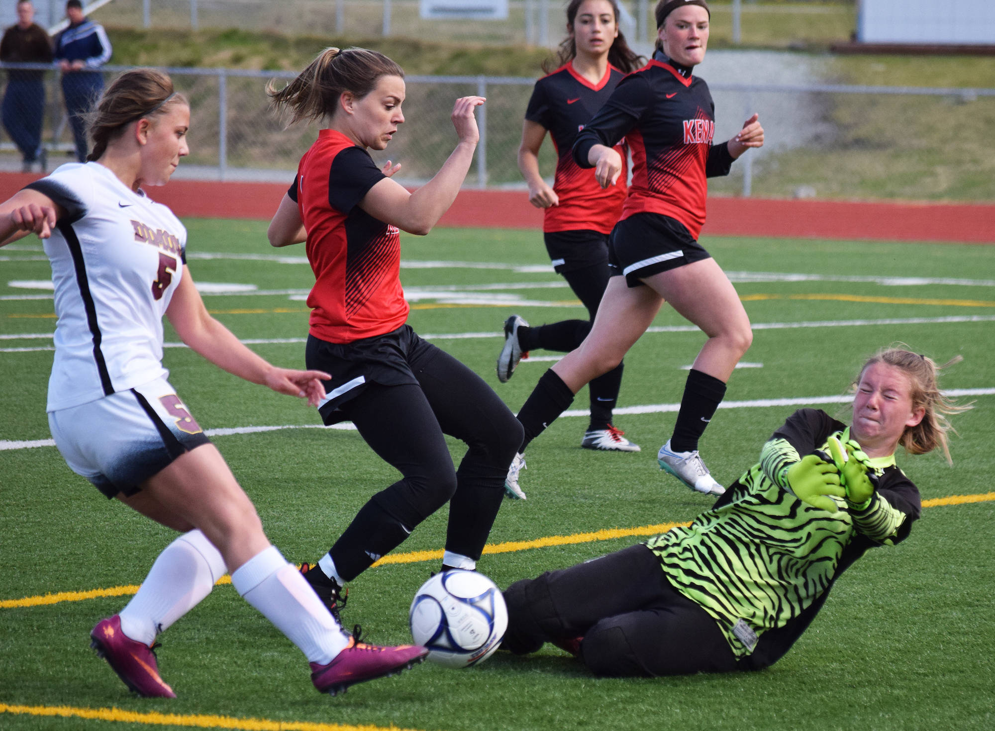 Kenai Central goalkeeper Kailey Hamilton blocks a shot from Dimond’s Kelsey Eagle, Thursday at the girls state soccer tournament at Eagle River High School. (Photo by Joey Klecka/Peninsula Clarion)