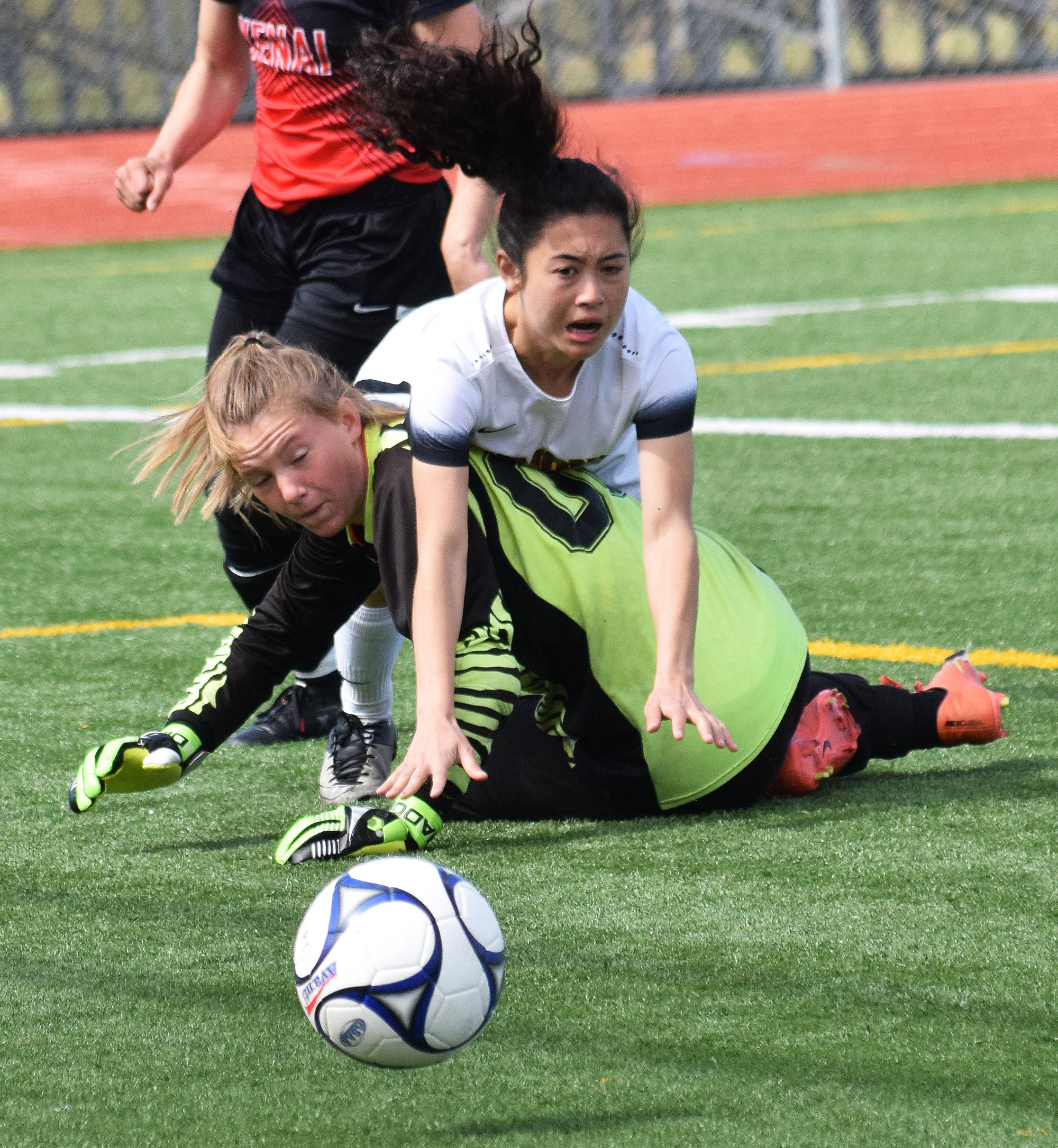 Dimond’s Allison Shafer collides with Kenai Central goalkeeper Kailey Hamilton in a quarterfinal matchup Thursday at the state soccer tournament at Eagle River High School. (Photo by Joey Klecka/Peninsula Clarion)