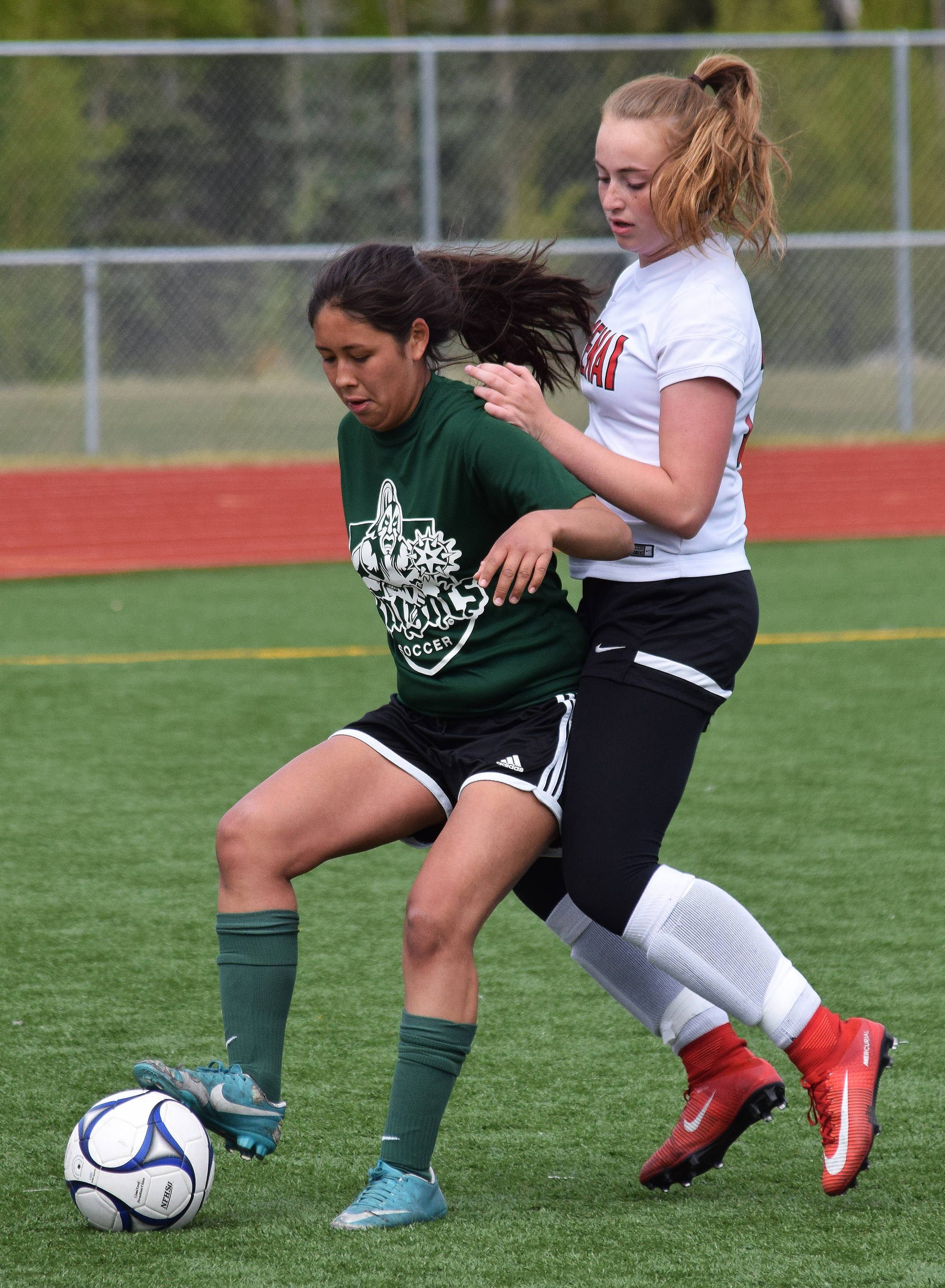 Colony’s Kira Fagerstrom (left) battles for possession against Kenai Central’s Liz Hanson in a consolation semifinal Friday at the girls state soccer tournament at Eagle River High School. (Photo by Joey Klecka/Peninsula Clarion)
