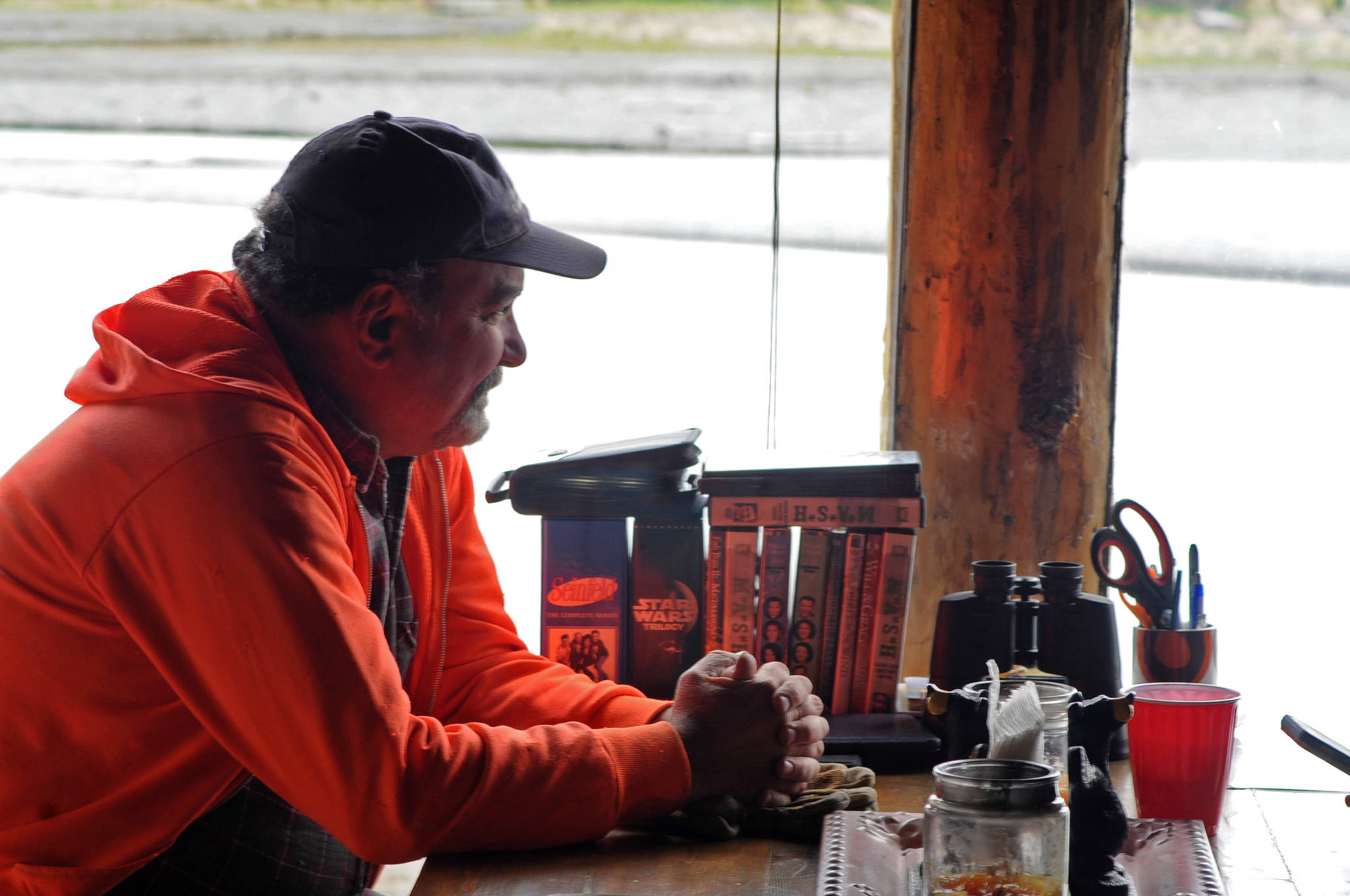 Steve Flick, one of the property owners on Dow Island’s north bank, relaxes in Natalie and Chad Smyre’s cabin on the island Saturday, May 27, 2017 in Funny River, Alaska. Flick, a professional construction contractor in Missouri, worked with the Smyres and two other property owners to install an extensive bank restoration project on the island to preempt the Kenai River’s erosion that has been washing away feet of their properties each year. (Elizabeth Earl/Peninsula Clarion)  Steve Flick, one of the property owners on Dow Island’s north bank, relaxes in Natalie and Chad Smyre’s cabin on the island Saturday, May 27, 2017 in Funny River, Alaska. Flick, a professional construction contractor in Missouri, worked with the Smyres and two other property owners to install an extensive bank restoration project on the island to preempt the Kenai River’s erosion that has been washing away feet of their properties each year. (Elizabeth Earl/Peninsula Clarion)