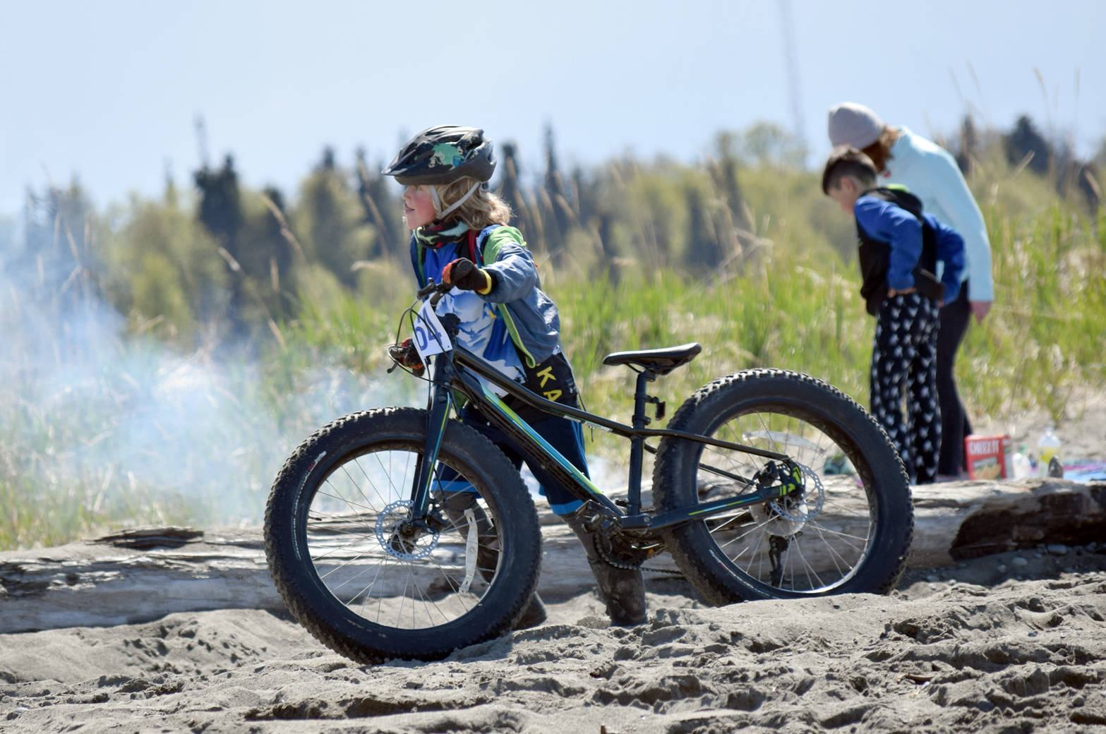 Lukas Renner, 8, gets off his bike to walk through the soft sand before the final hill to the finish Monday, May 29, 2017, at the Mouth to Mouth Wild Run and Ride. Many riders were calling that soft sand and hill the toughest part of the course. (Photo by Jeff Helminiak/Peninsula Clarion)