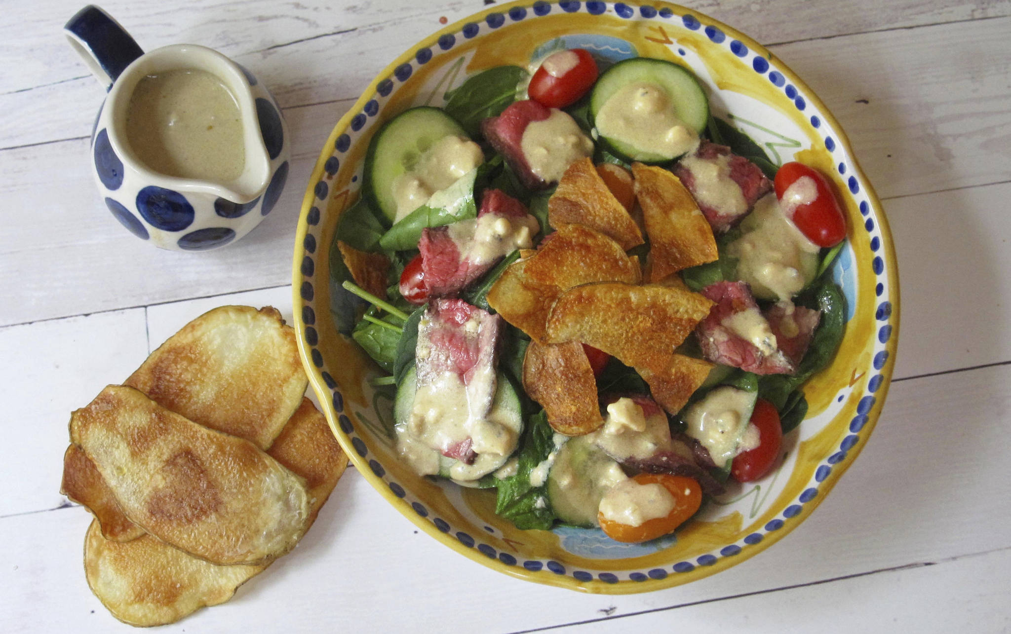 This May 20, 2017 photo shows a warm steak and potato chip salad with blue cheese dressing in New York. This dish is from a recipe by Sara Moulton. (Sara Moulton via AP)