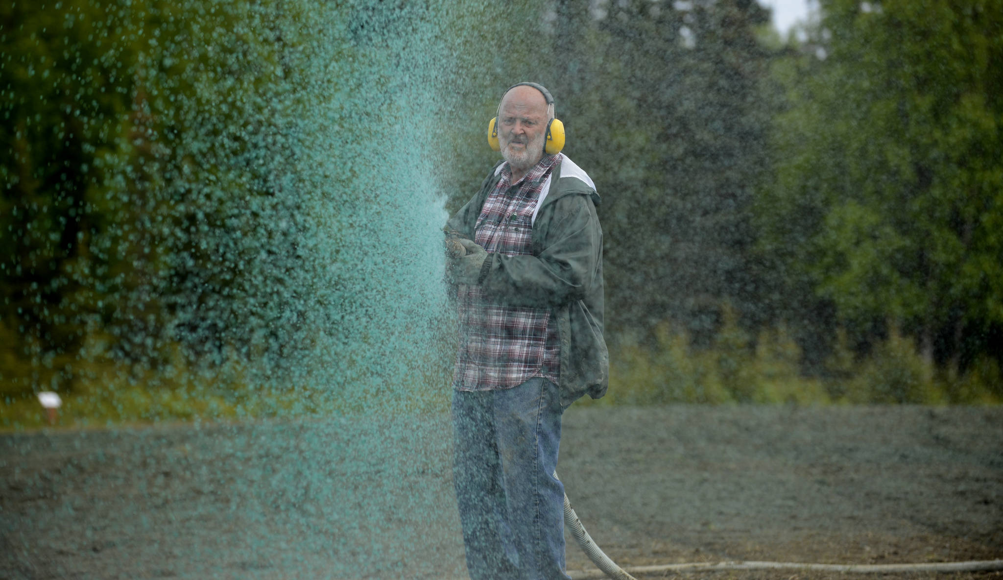 Charles Woodcock of Woodcock’s Hydroseeding sprays a mix of water, fertilizer, paper pulp, and wildflower seeds across the soon-to-be Kenai Field of Flowers on Monday, June 5. Since 2014, Kenai’s municipal government has been turning the vacant city-owned lot into a summer attraction by seeding it with 15 varieties of wildflower, which Kenai Parks and Recreation Director Bob Frates said include lupin, poppies, cosmos, columbine, cornflower, baby’s breath, flax, and forget-me-not. After a drizzling Monday morning, Woodcock started spraying the field at noon — the ground’s dampness, he said, makes it better for seeding. In past years, the flowers have usually started to sprout in mid-July. Frates said that hydroseeding the approximately 55,000 square feet of the field costs about $5,400.
