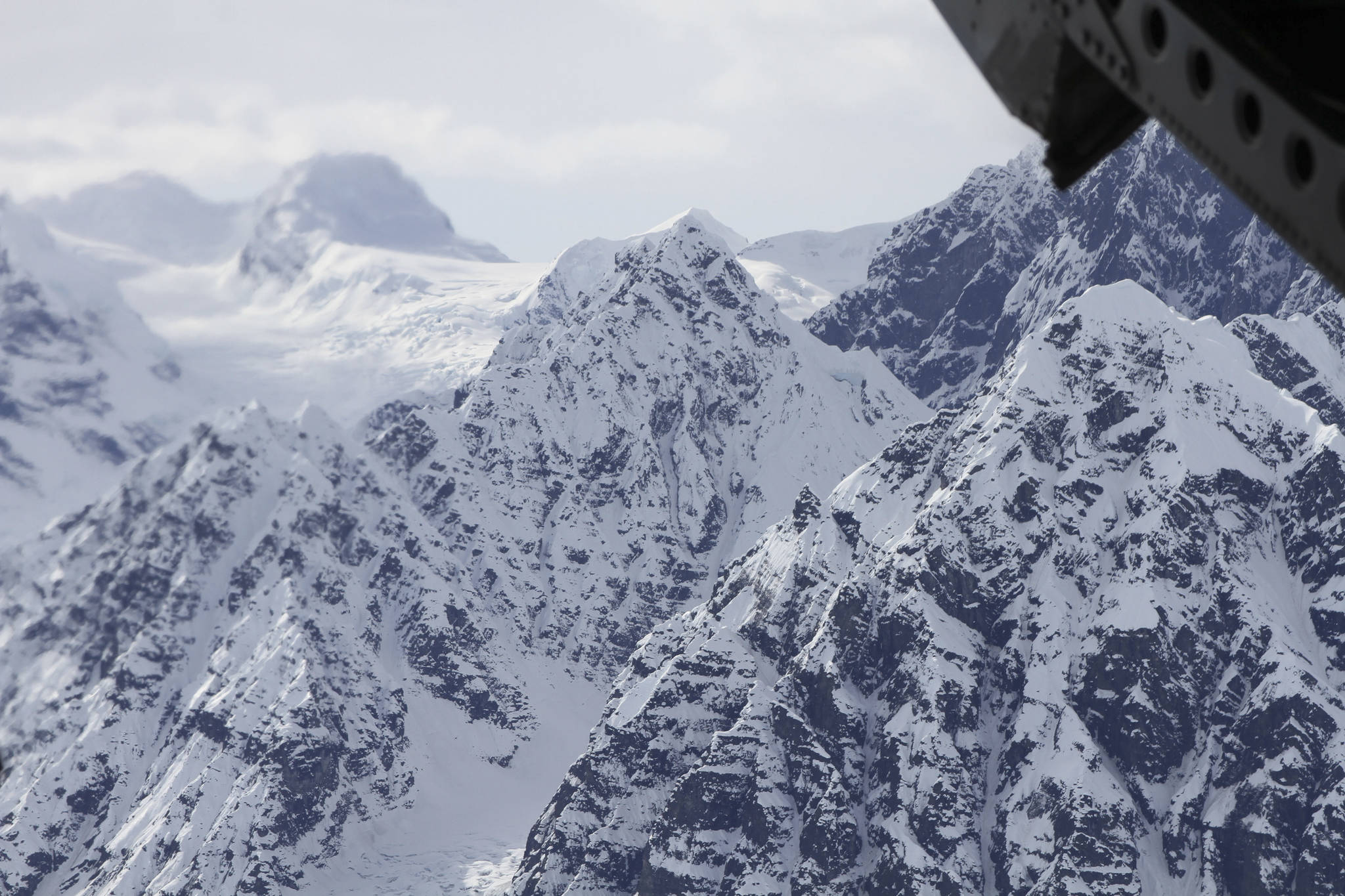 FILE - This April 24, 2016, file photo taken above the Kahiltna Glacier near Denali, shows peaks in the Alaska Range, as seen through the open cargo bay doors of a Chinook helicopter. Rangers rescued two climbers in unrelated incidents from Kahiltna Glacier in Denali National Park on Monday, June 5, 2017. (AP Photo/Mark Thiessen, File)