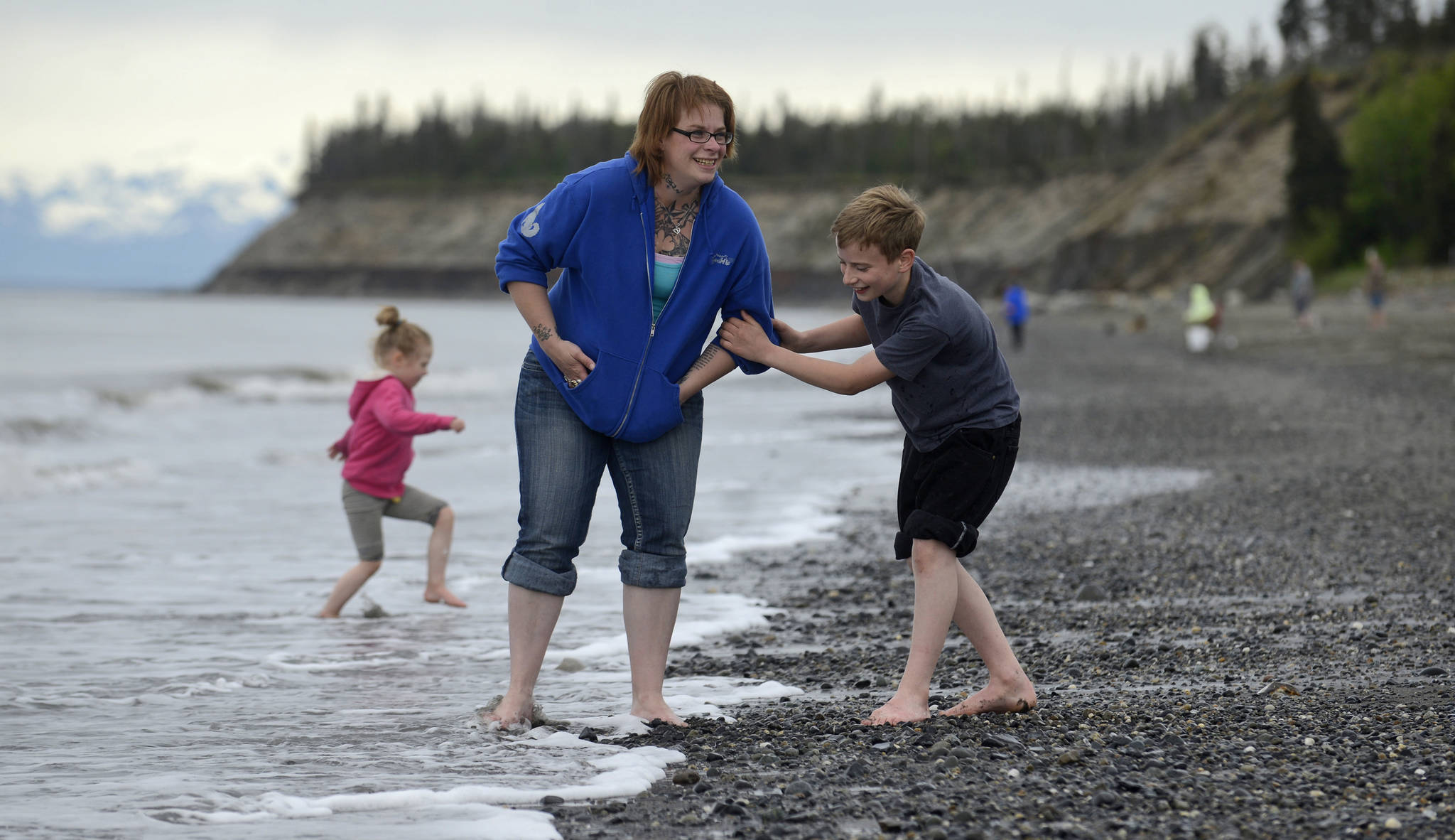 Carrie Gaethle and her children Ayla Gaethle (left) and Andrew Gaethle play in the surf on Kenai’s north beach on Tuesday, June 6, 2017 in Kenai. (Ben Boettger/Peninsula Clarion)