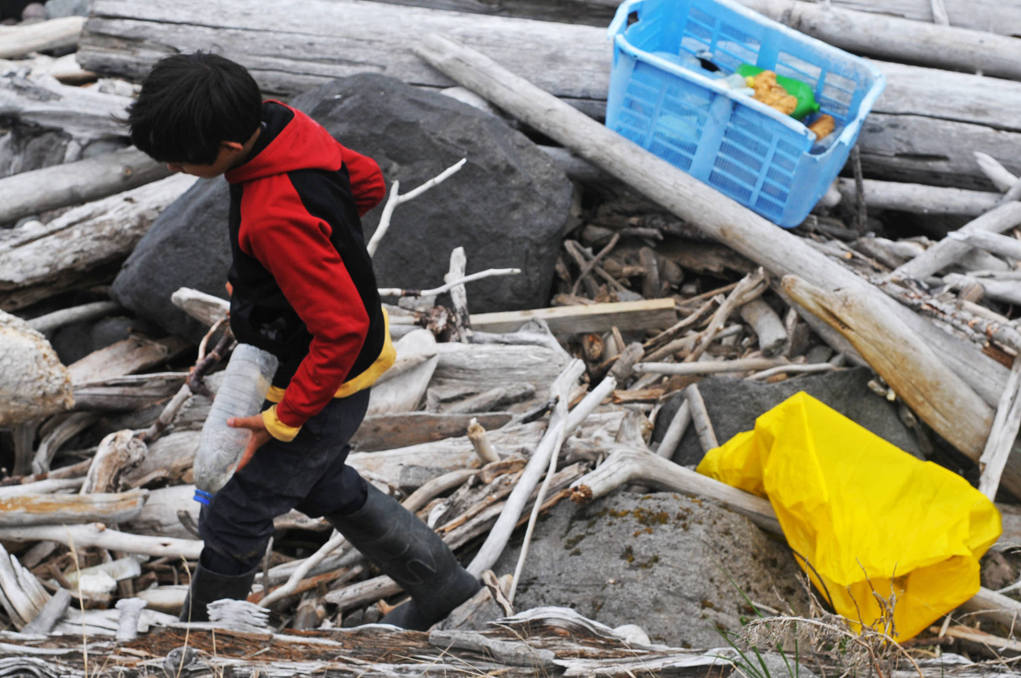 Gautoma Iwamura, a homeschool student through the Kenai Peninsula Borough School District’s Connections program, gathers trash on Sunday, June 4, 2017 on Augustine Island, Alaska. Iwamura was one of a group of students and adults who traveled with the Center for Alaskan Coastal Studies to the remote island in Cook Inlet to gather marine debris from the beaches. (Photo by Elizabeth Earl/Peninsula Clarion)