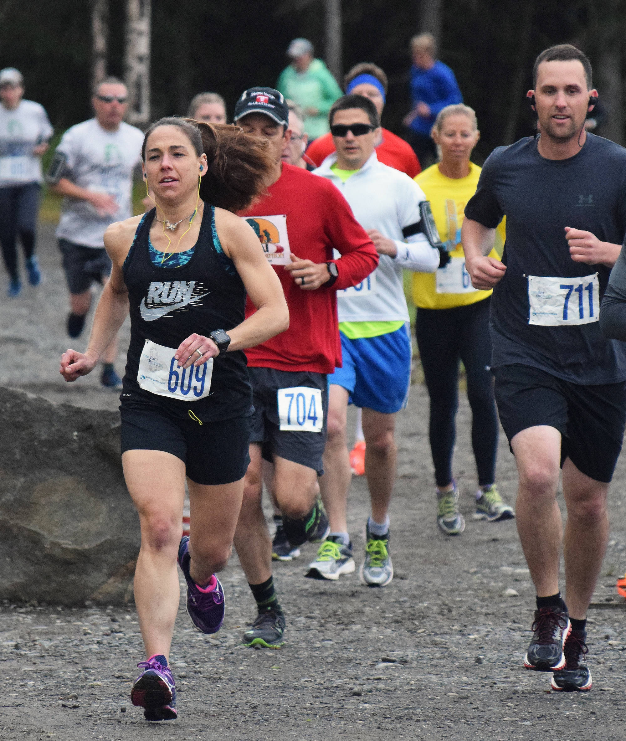 Women’s Run for the River 10-mile runner-up Heather Moon (609) leads a pack of racers out onto the course Saturday morning in Soldotna, with women’s 10-mile race winner Bethany Tietz (in yellow shirt) following closely. (Photo by Joey Klecka/Peninsula Clarion)