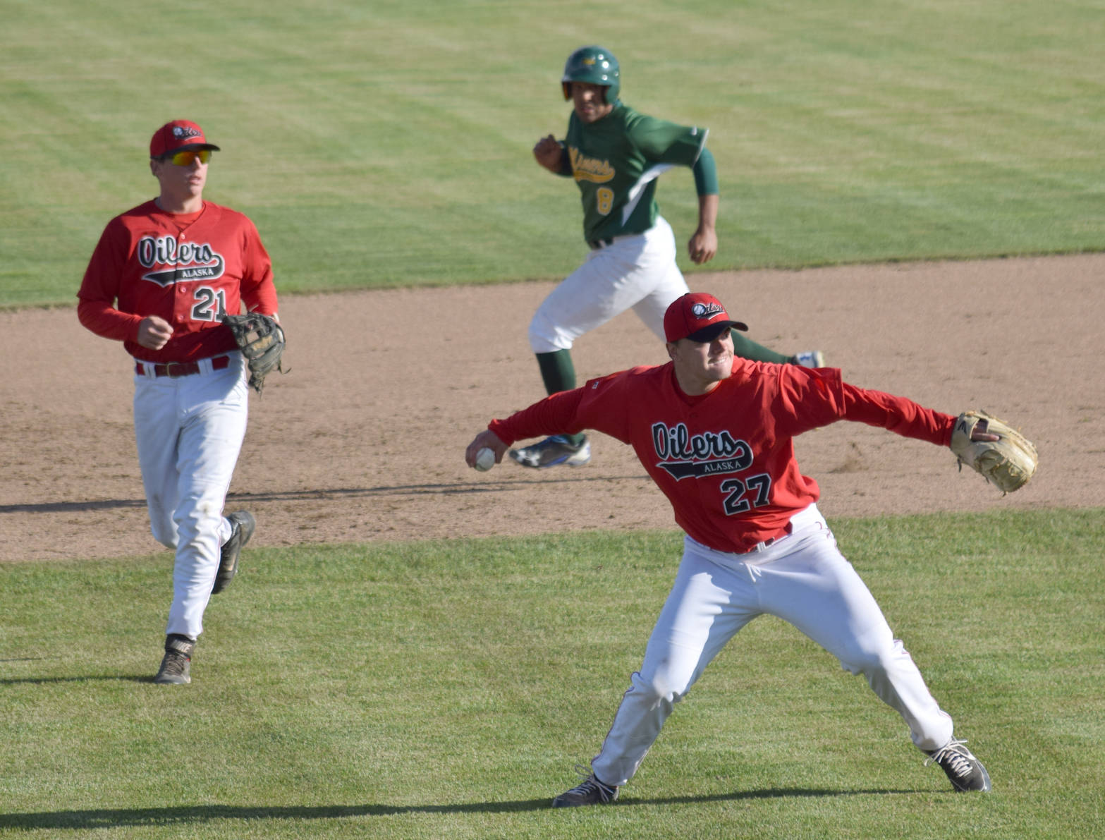 Oilers pitcher Devin Hayes throws to first to get Quin Cotton of the Miners and end a threat in the top of the fourth inning Monday, June 13, 2017, at Coral Seymour Memorial Park in Kenai. Caleb Hicks of the Oilers backs up the play while Oscar Marchena of the Miners runs to third. (Photo by Jeff Helminiak/Peninsula Clarion)