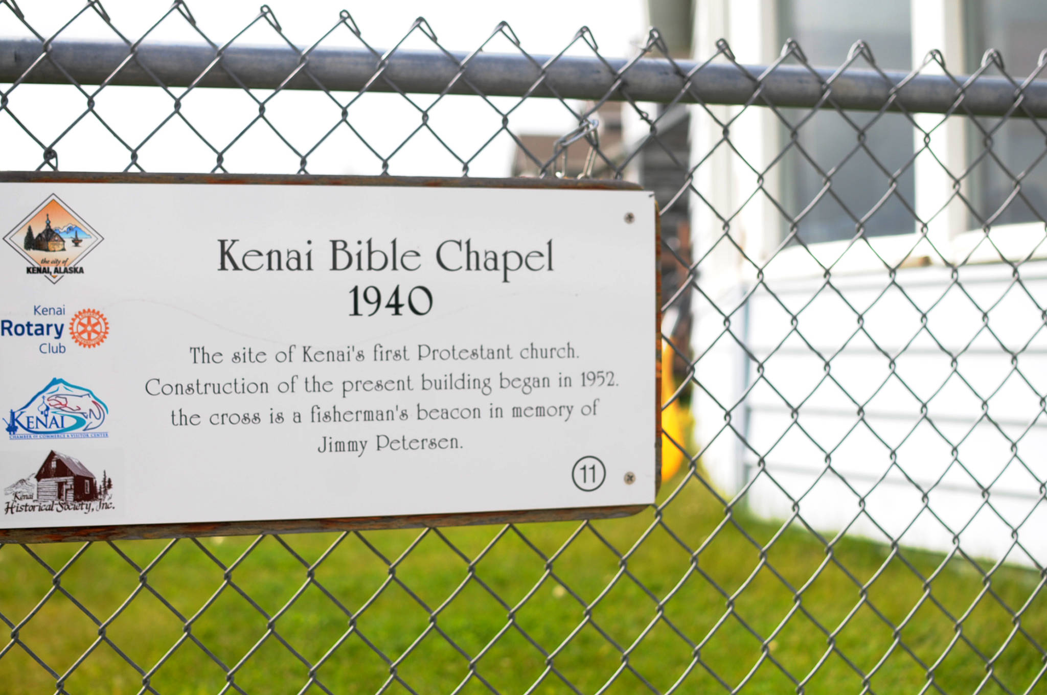 A historical marker hangs on the fence outside the Kenai Bible Church on Monday, June 12, 2017 in Kenai, Alaska. The chapel, which overlooks the Kenai River in Old Town Kenai, is the oldest Protestant church in town and will celebrate its 75th anniversary this year. (Photo by Elizabeth Earl/Peninsula Clarion)