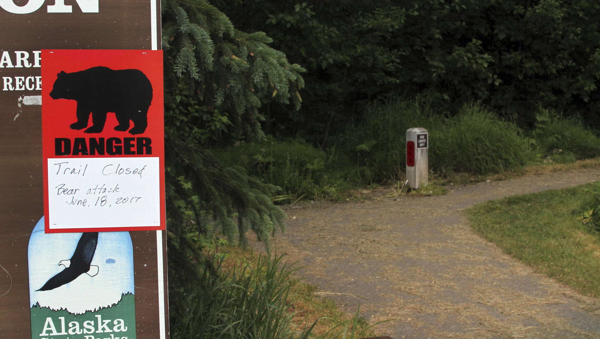 A sign warns people that the trail head is closed on Monday after a fatal bear mauling at Bird Ridge Trail in Anchorage. Authorities say a black bear killed a 16-year-old runner while he was competing in a race on Sunday. (AP Photo/Mark Thiessen)