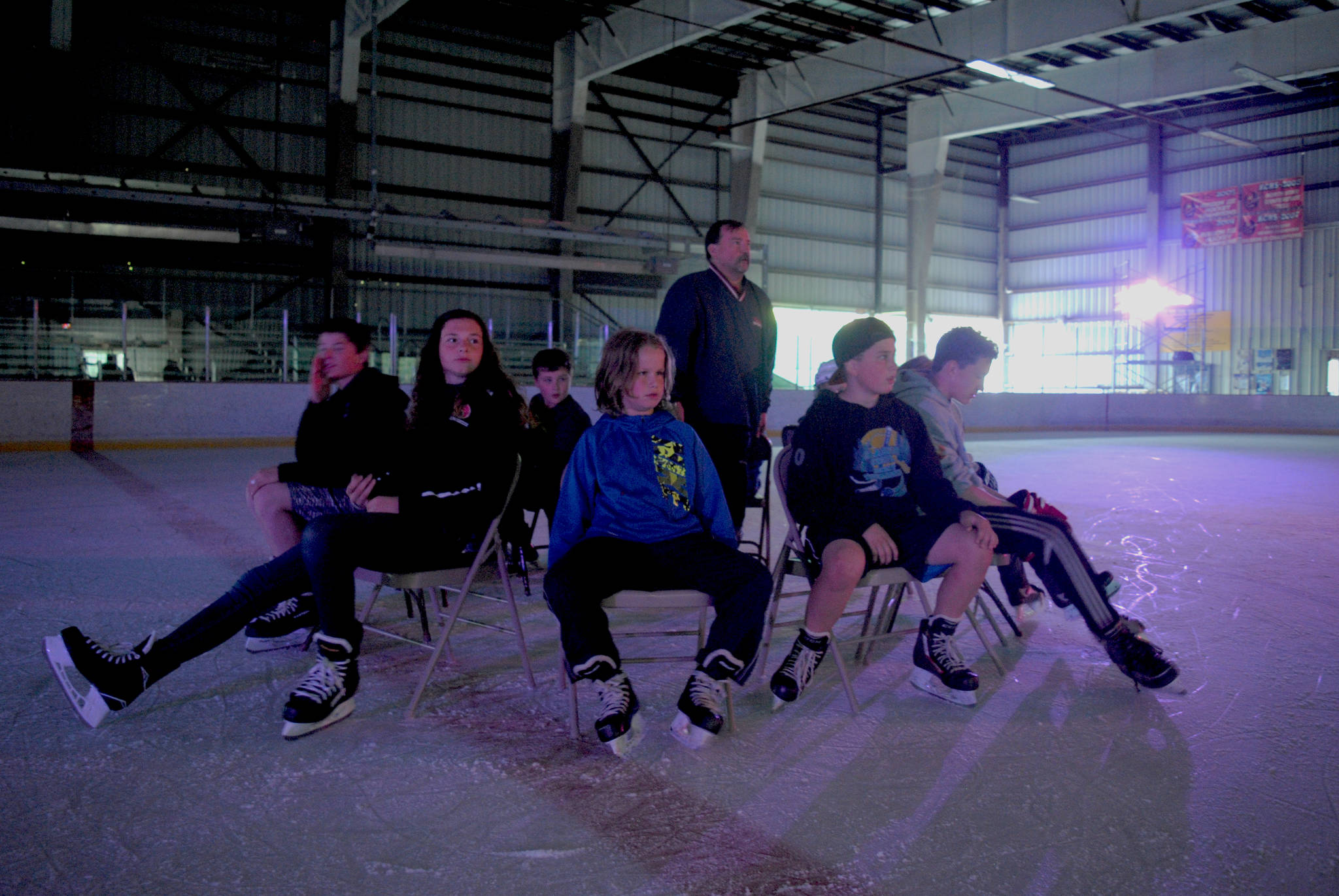 Event organizer Vince Redford, standing, and participants of Friday Night Lights at the ConocoPhillips Kenai Multipurpose Facility in Kenai keep their eyes on the music booth during a game of musical chairs on June 16. The weekly event runs from 8 p.m. to 10 p.m. and offers a wide variety of games played on the ice. (Photo by Kat Sorensen/Peninsula Clarion)