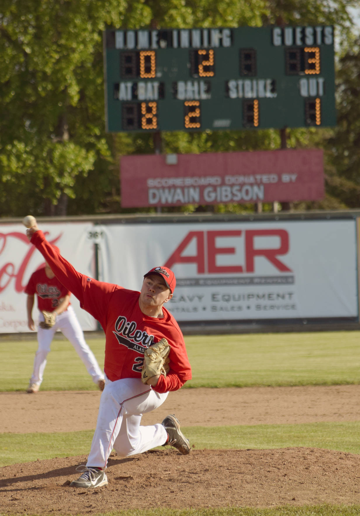 Devin Hayes delivers a pitch to the Mat-Su Miners on June 13, 2017, at Coral Seymour Memorial Park in Kenai. Behind Hayes is the scoreboard, which was in its final Oilers game after almost 40 years. (Photo by Jeff Helminiak/Peninsula Clarion)