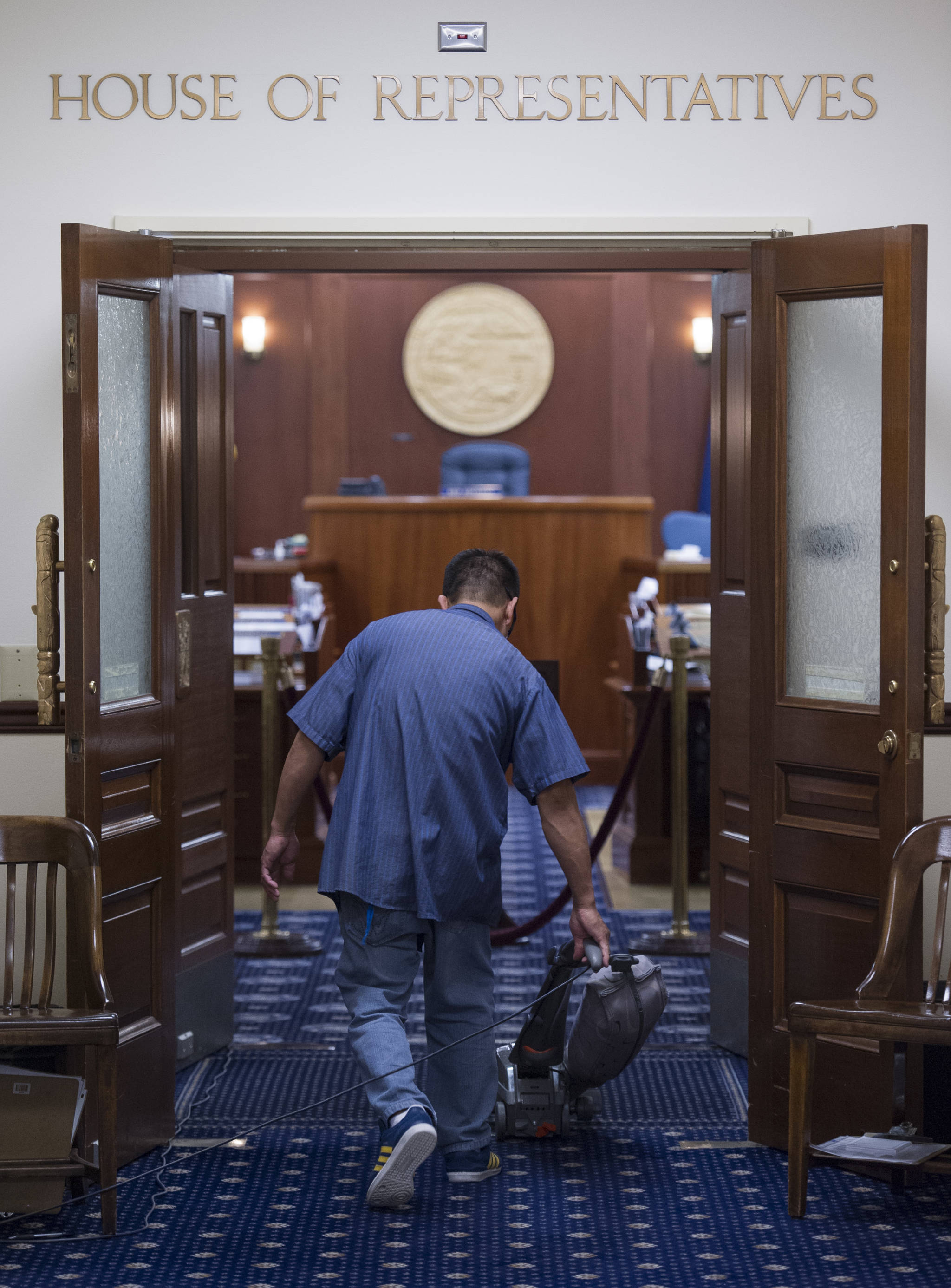 A janitor vacuums at the Capitol just before midnight Thursday, June 23, 2017, after both the House and Senate voted to approve a budget and keep the State of Alaska from shutting down on July 1. (Michael Penn | Juneau Empire)