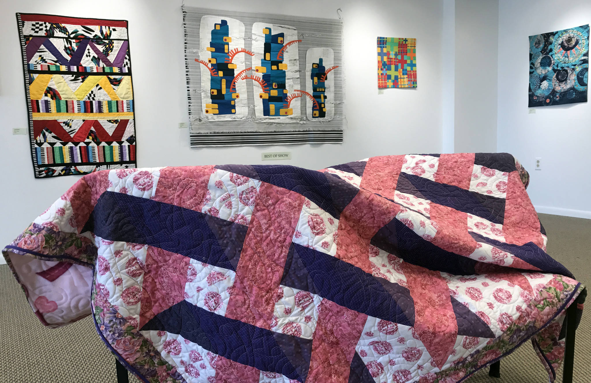 Ann-Lillion Schell is donating a pink and purple quilt to the Kenai Fine Art Center’s Annual Harvest Auction, to be held September 30, 2017 in Kenai, Alaska. She also has work hanging in the center’s monthly gallery installation, “Arts Quilts Extra-Ordinaire,” which will run until July 1. (Photo by Kat Sorensen/Peninsula Clarion)
