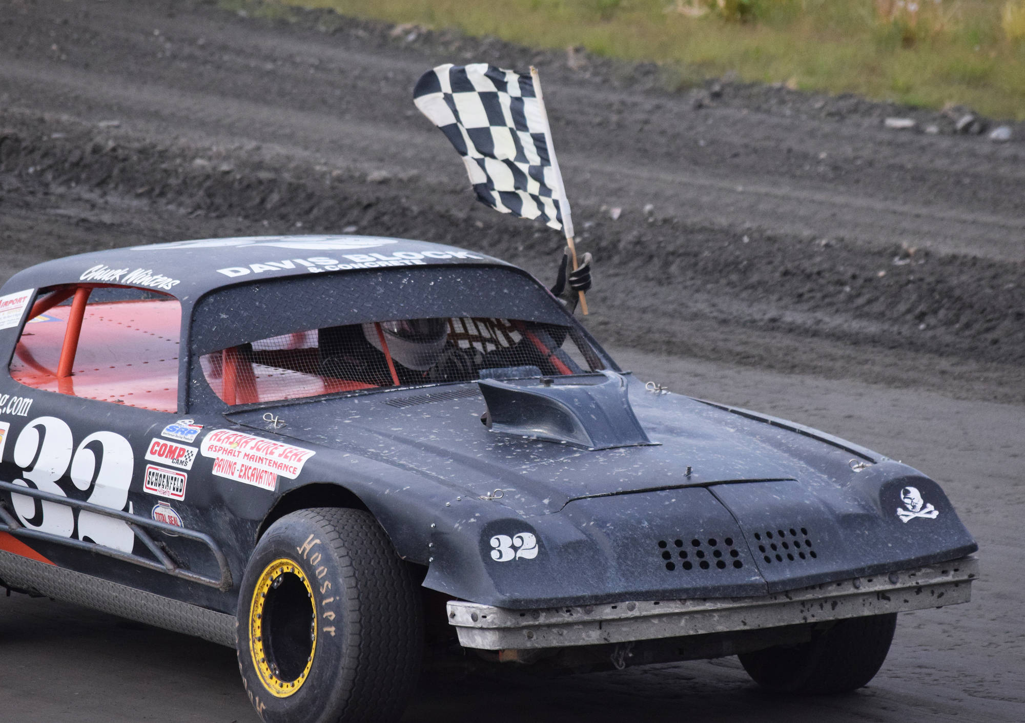 B-Stock driver Chuck Winters takes the checkered flag for a victory lap after winning the 50-lap “Filthy Fifty” feature race Saturday night at Twin City Raceway in Kenai. (Photo by Joey Klecka/Peninsula Clarion)