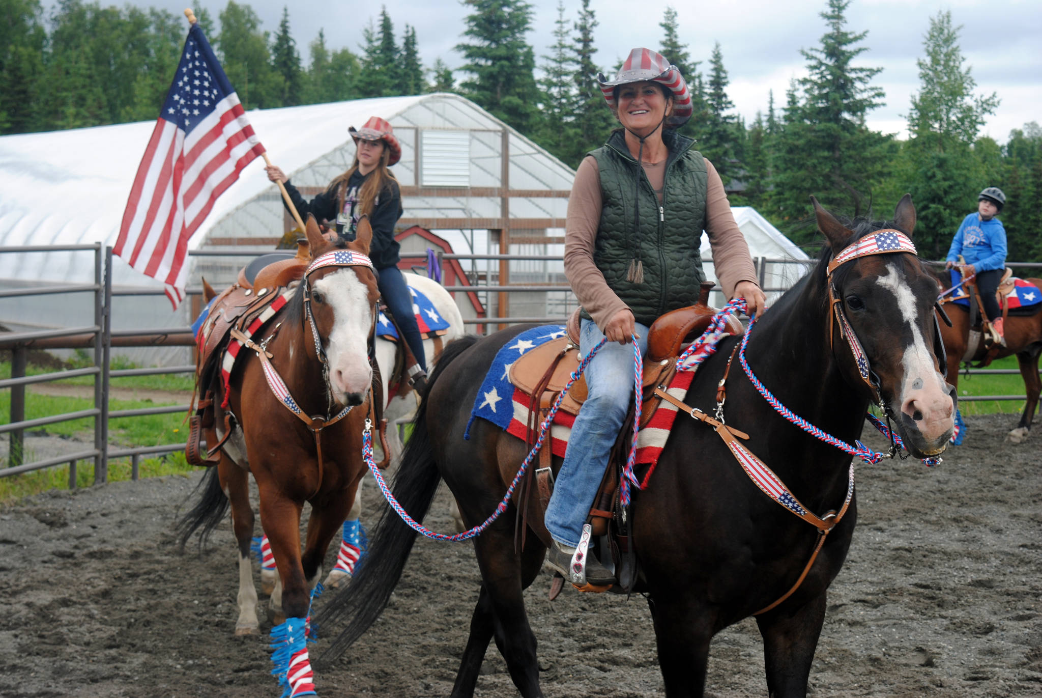 Connie Green, right, owner of Alaska C&C Horse Adventures in Soldotna, practices with Madelyn Barkman, left, on Monday in preparation for the Kenai Fourth of July Parade. (Photo by Kat Sorensen/Peninsula Clarion)