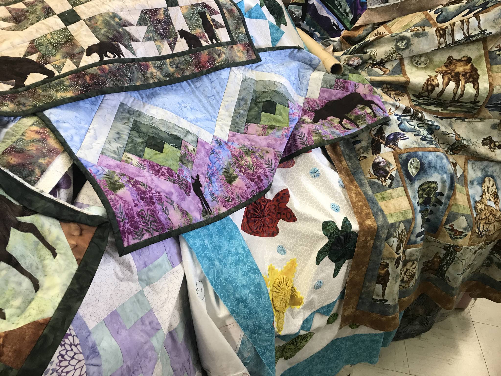 A selection of Dana Woodard’s quilted artwork is on display at her family’s store, Kenai Fabric Center, in Kenai. Gwen Woodard, Dana’s mother, says that a major part of their sales are based on Dana’s designs and patterns. (Photo by Kat Sorensen/Peninsula Clarion)