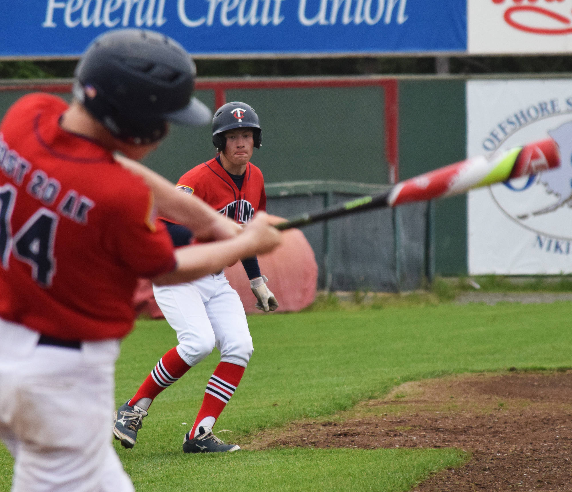 Post 20 Twins’ Jeremy Kupferschmid watches teammate Mose Hayes take a swing against South Post 4 Saturday at Coral Seymour Memorial Park in Kenai. (Photo by Joey Klecka/Peninsula Clarion)