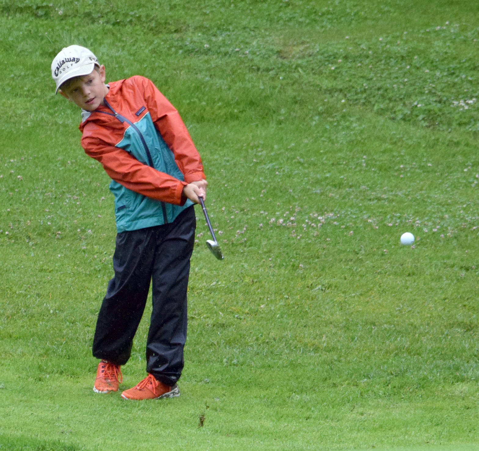 Richie Lundahl III chips to the eighth green Tuesday, July 18, 2017, at the Birch Ridge Junior Masters at Birch Ridge Golf Course in Soldotna. (Photo by Jeff Helminiak/Peninsula Clarion)