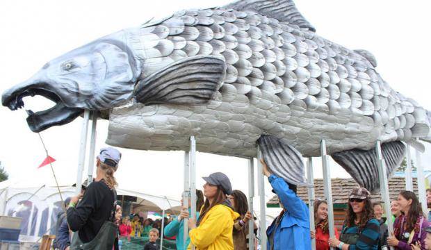 Salmonfest attendees parade through the festival grounds carrying a large, handmade salmon at the 2016 festival in Ninilchik. (Clarion file photo)