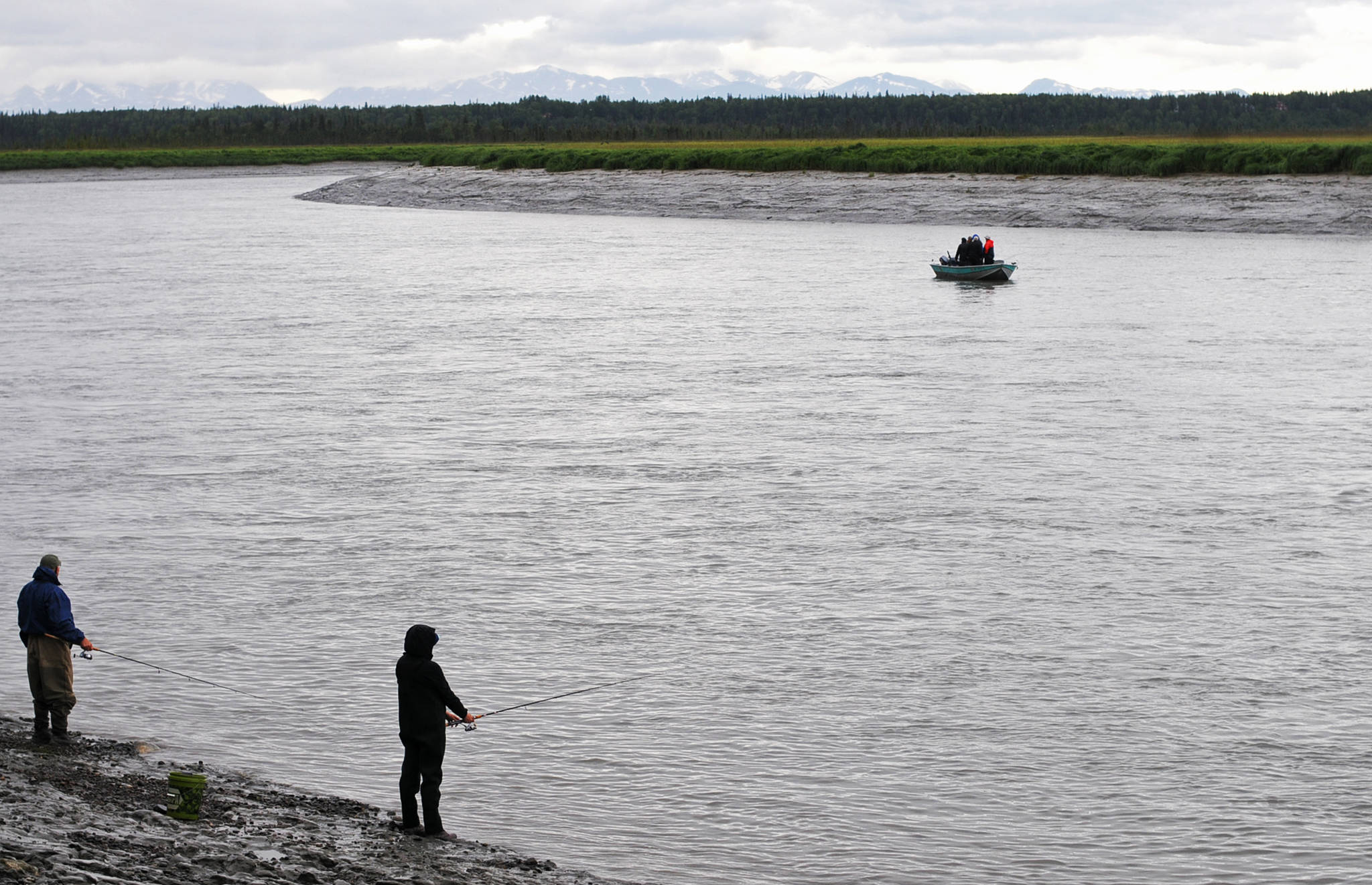 Anglers cast for sockeye salmon from the Kenai River bank at Cunningham Park on Wednesday, July 19, 2017 in Kenai, Alaska. After several days of heavy rain across the central Kenai Peninsula, the weather began to clear Wednesday, with the rain predicted to clear Thursday in exchange for clouds and some sunshine, transitioning to mixed clouds and sunshine and temperatures in the mid-60s, according to the National Weather Service. (Photo by Elizabeth Earl/Peninsula Clarion)