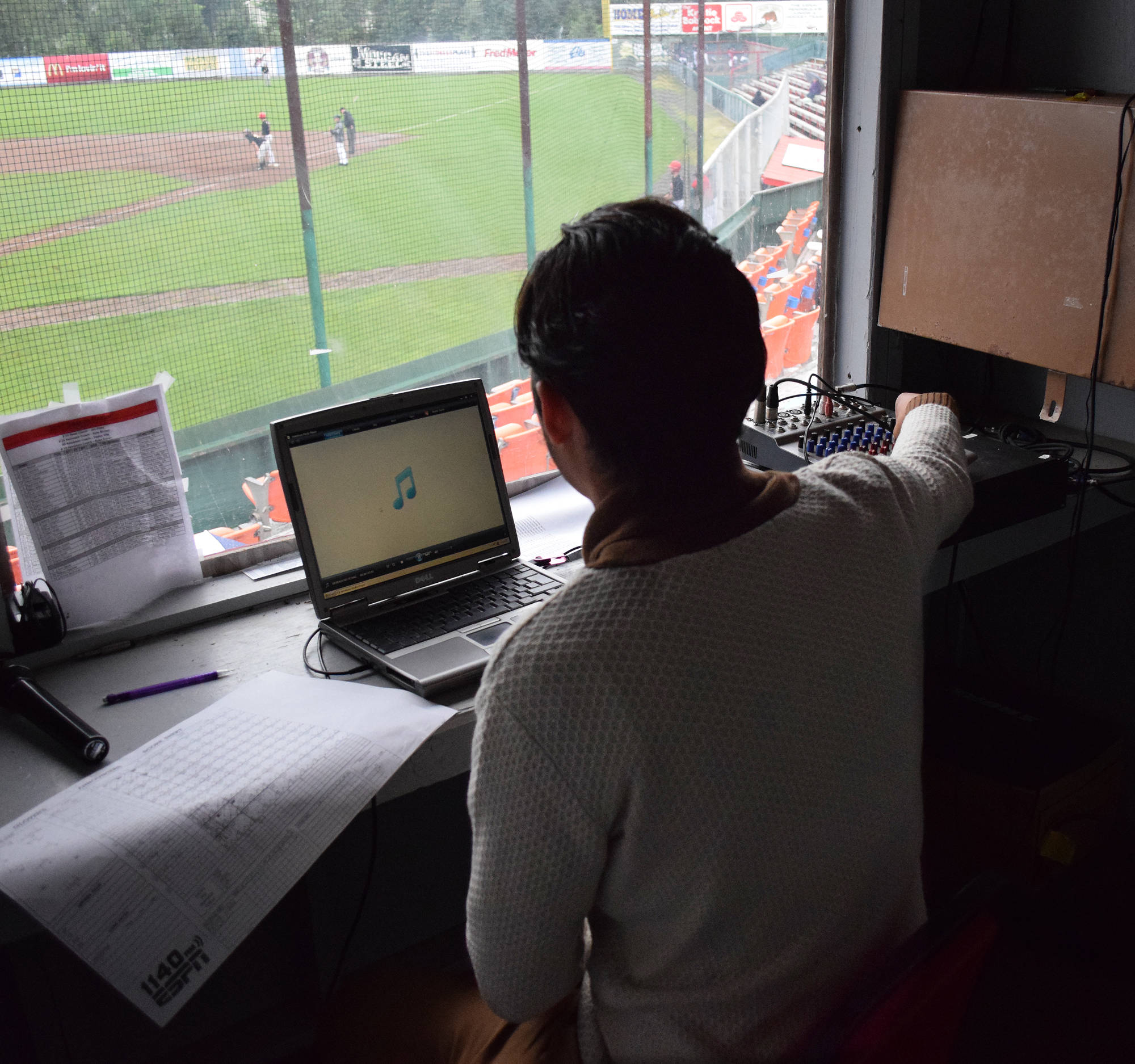 Peninsula Oilers public address announcer Casey Roehl keeps score in the press booth at Coral Seymour Memorial Ballpark during a July 19 Alaska Baseball League contest against the Anchorage Bucs. (Photo by Joey Klecka/Peninsula Clarion)