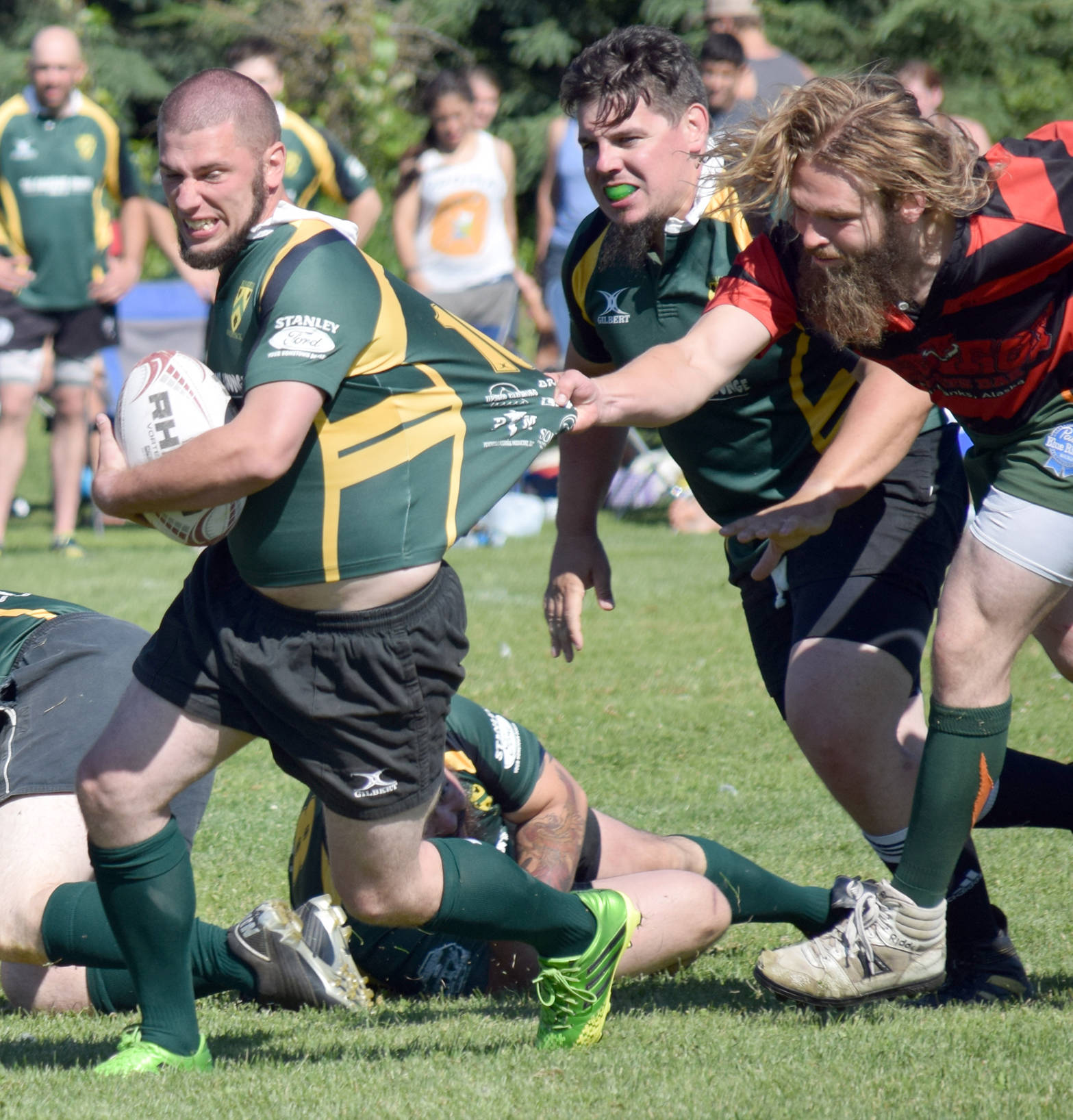 Trent Buning of Kenai River Wolfpack tries to escape the grasp of Samuel Warner of the Fairbanks Sun Dawgs on Saturday, July 22, 2017, at the Kenai Dipnet Fest Rugby 10s Tournament in Kenai. Danny Autrey Jr. of the Woldpack looks on. (Photo by Jeff Helminiak/Peninsula Clarion)