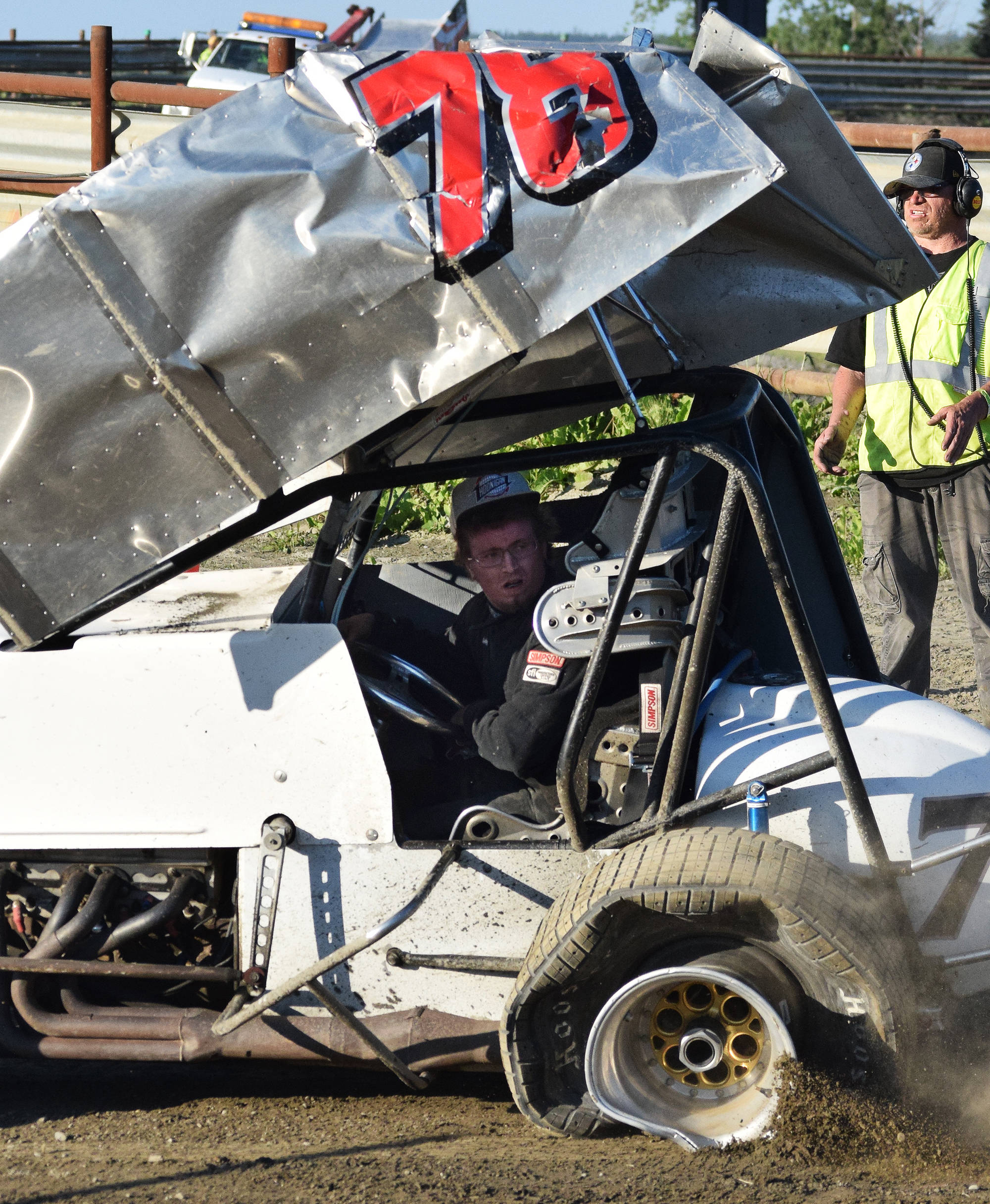 Logan McDonald steers his father John’s crumpled No. 78 Sprint car back to the pits after John endured a rollover crash during the running of the Alaska Dirt Track Shootout held Saturday at Twin City Raceway in Kenai. (Photo by Joey Klecka/Peninsula Clarion)