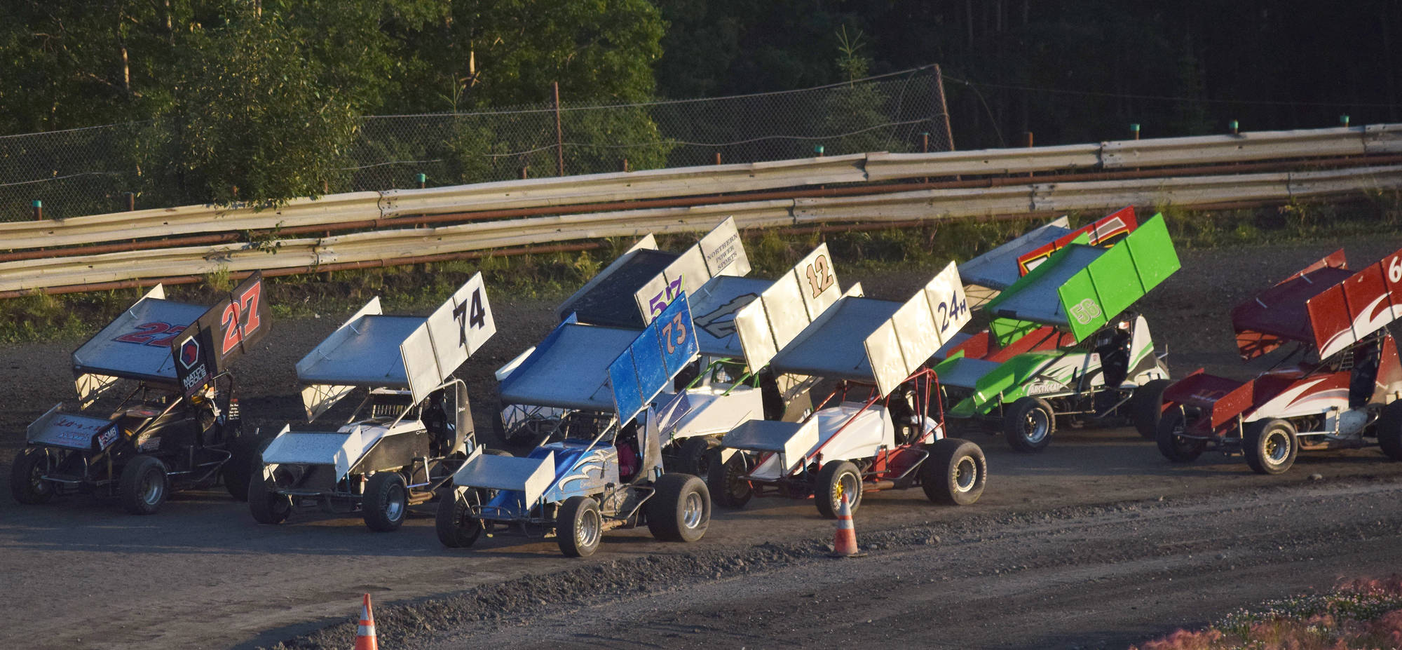 A field of 14 Sprint Cars line up in a traditional three-wide “Salute to the Fans” during the running of the Alaska Dirt Track Shootout held Saturday at Twin City Raceway in Kenai. (Photo by Joey Klecka/Peninsula Clarion)