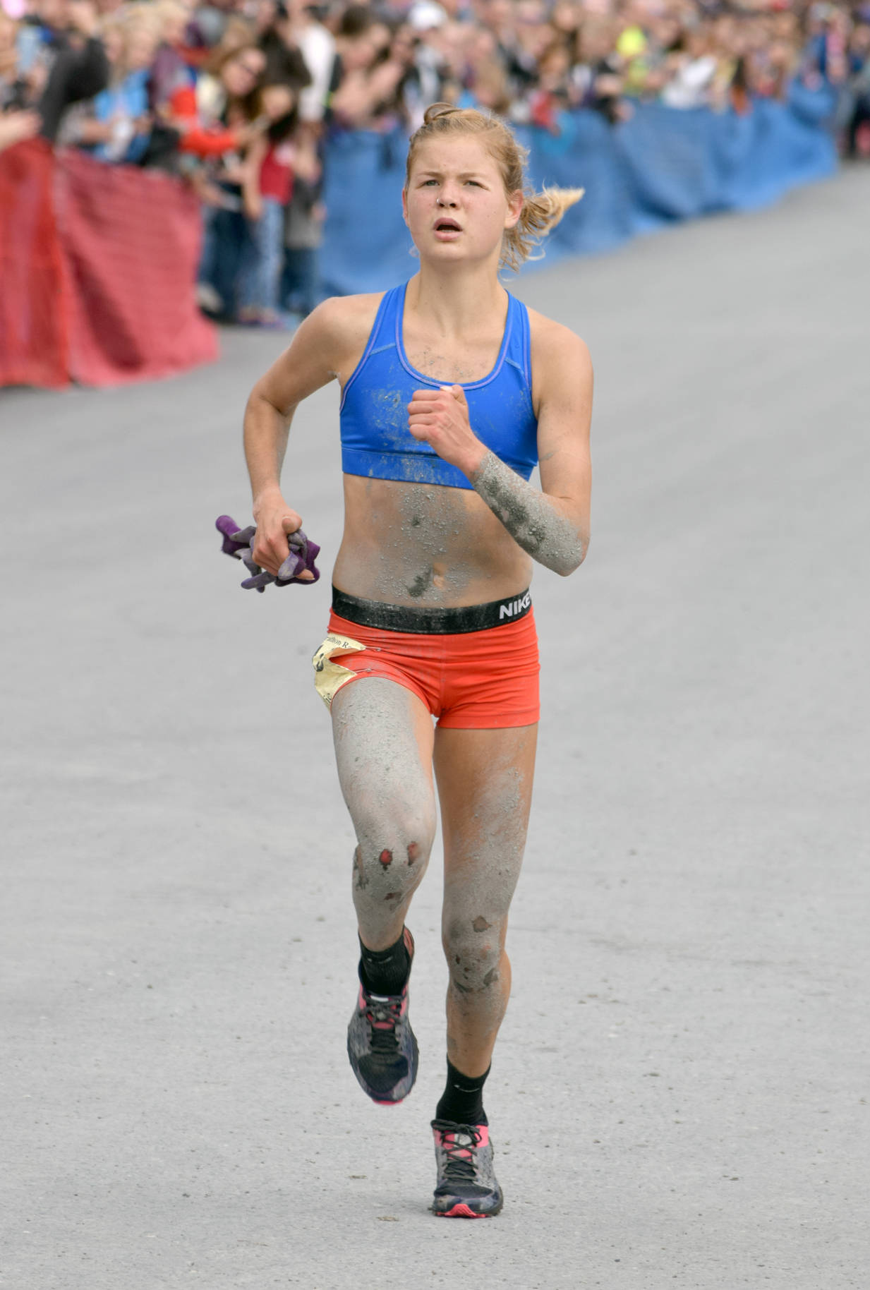 Mount Marathon women’s champ Allie Ostrander of Soldotna shows the effects of four tumbles at the top of the mountain July 4 in Seward. (Photo by Jeff Helminiak/Peninsula Clarion)