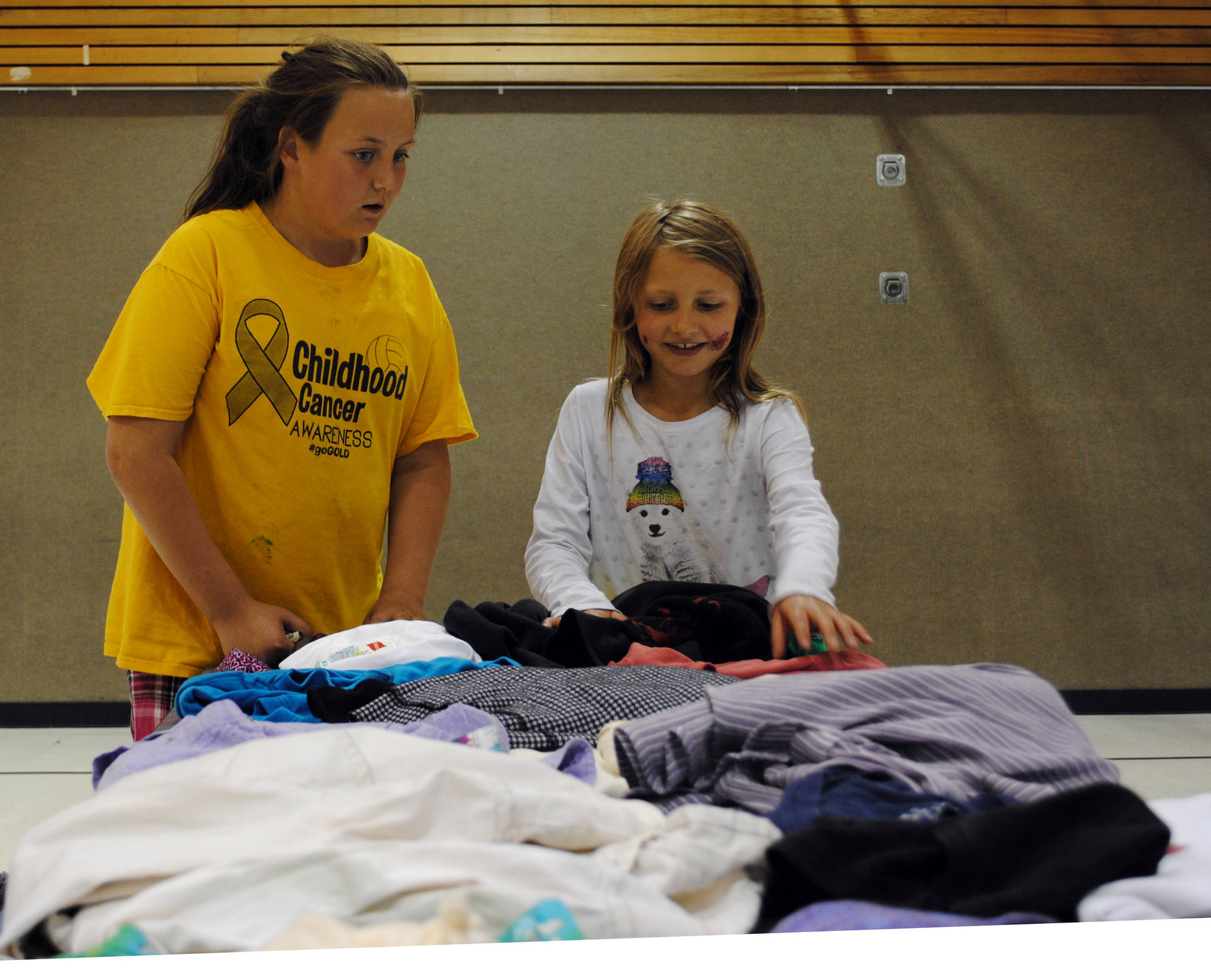 Taci Bettis (left) and Harmony Enders look through some clothes at Nikiski North Star Elementary School during the Boys & Girls Club of the Kenai Peninsula event offering free clothes, shoes and books on Monday, July 31, 2017 in Nikiski, Alaska. (Photo by Kat Sorensen/Peninsula Clarion)