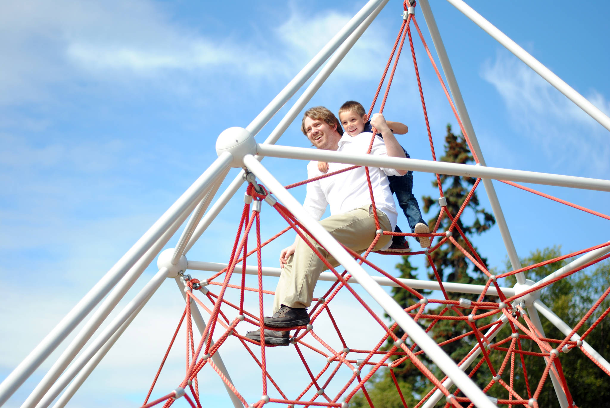 Six-year-old David Clyde joins Ty Grenier at the top of the rope climb at the Kenai Municipal Park’s Enchanted Forest playground Sunday, August 13, 2017 in Kenai, Alaska. After a bout of rainy weather, the playground was filled with families and friends enjoying the good weather. (Photo by Kat Sorensen/Peninsula Clarion)