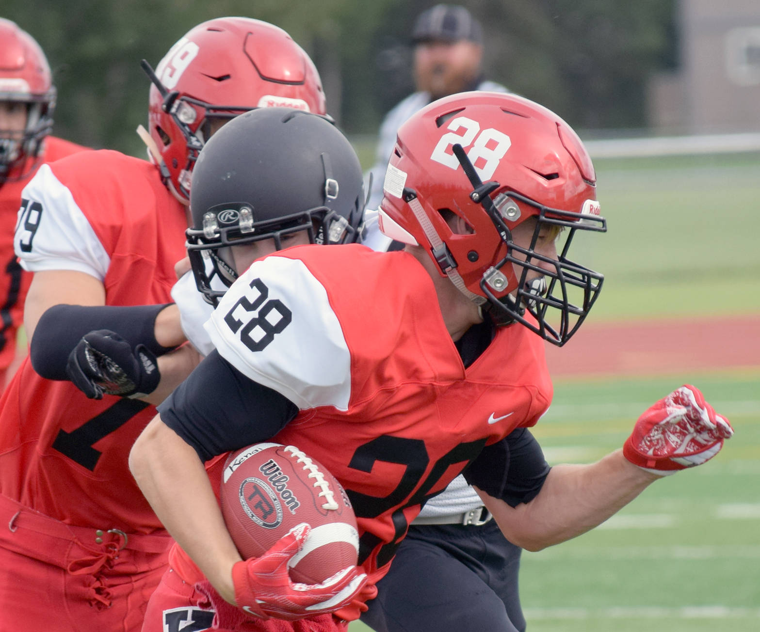 Kenai Central’s Rykker Riddall tries to elude the tackle of Nikiski’s Sam Berry during a scrimmage at Ed Hollier Field in Kenai on Friday, Aug. 11, 2017. (Photo by Jeff Helminiak/Peninsula Clarion)