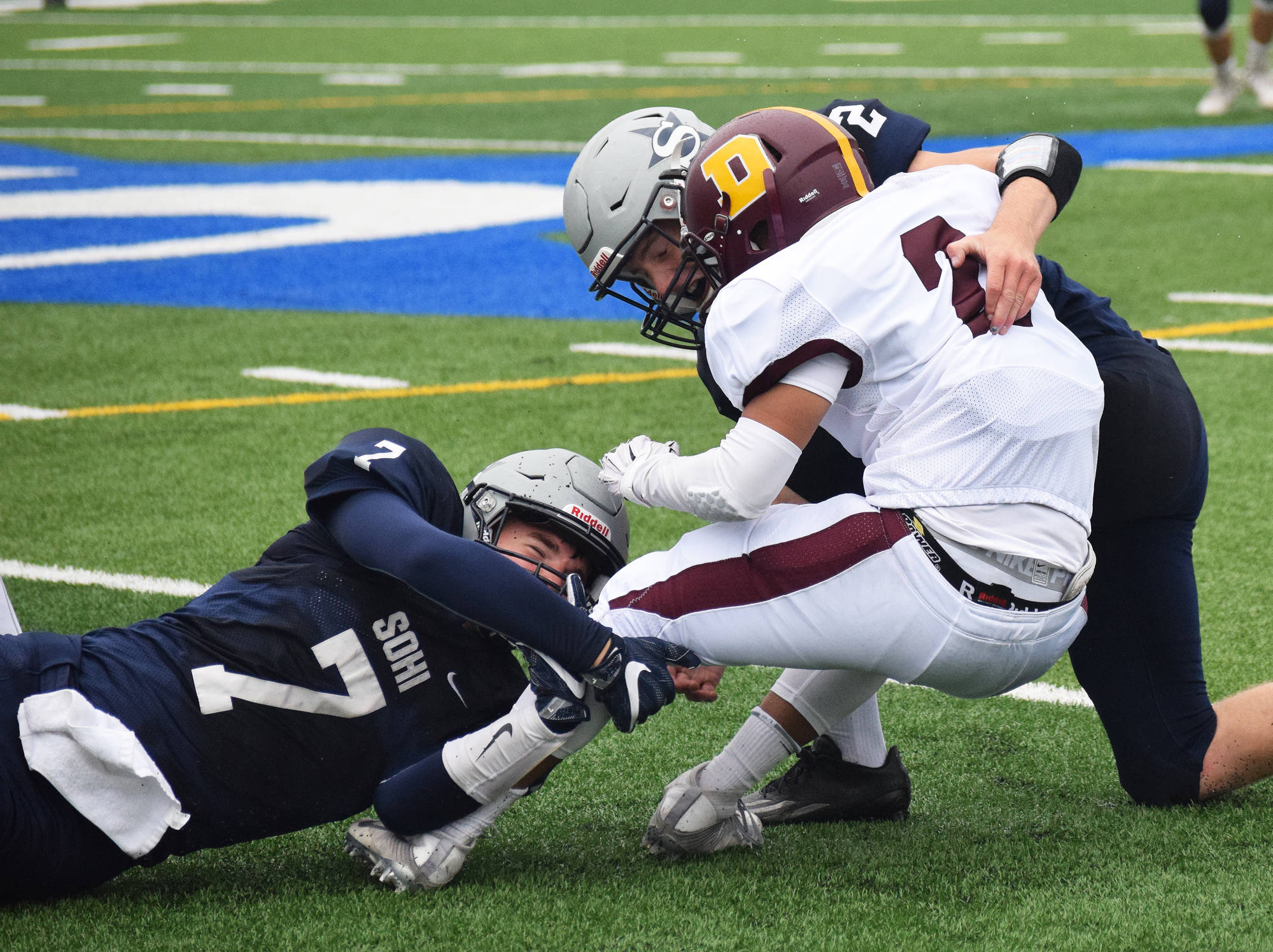 Soldotna linebackers Brandon Crowder (7) and Cody Quelland tackle Dimond running back Jaili Rescober Friday night at Justin Maile Field in Soldotna. (Photo by Joey Klecka/Peninsula Clarion)