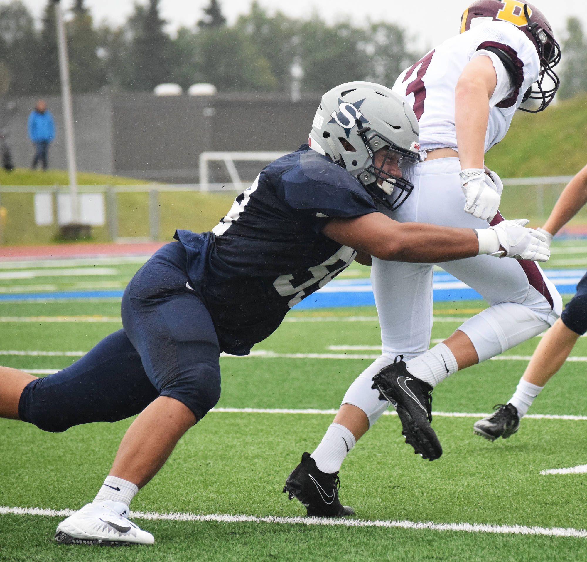 Soldotna lineman Wendell Tuisuala wraps up Dimond running back Ryan Beach Friday night at Justin Maile Field in Soldotna. (Photo by Joey Klecka/Peninsula Clarion)