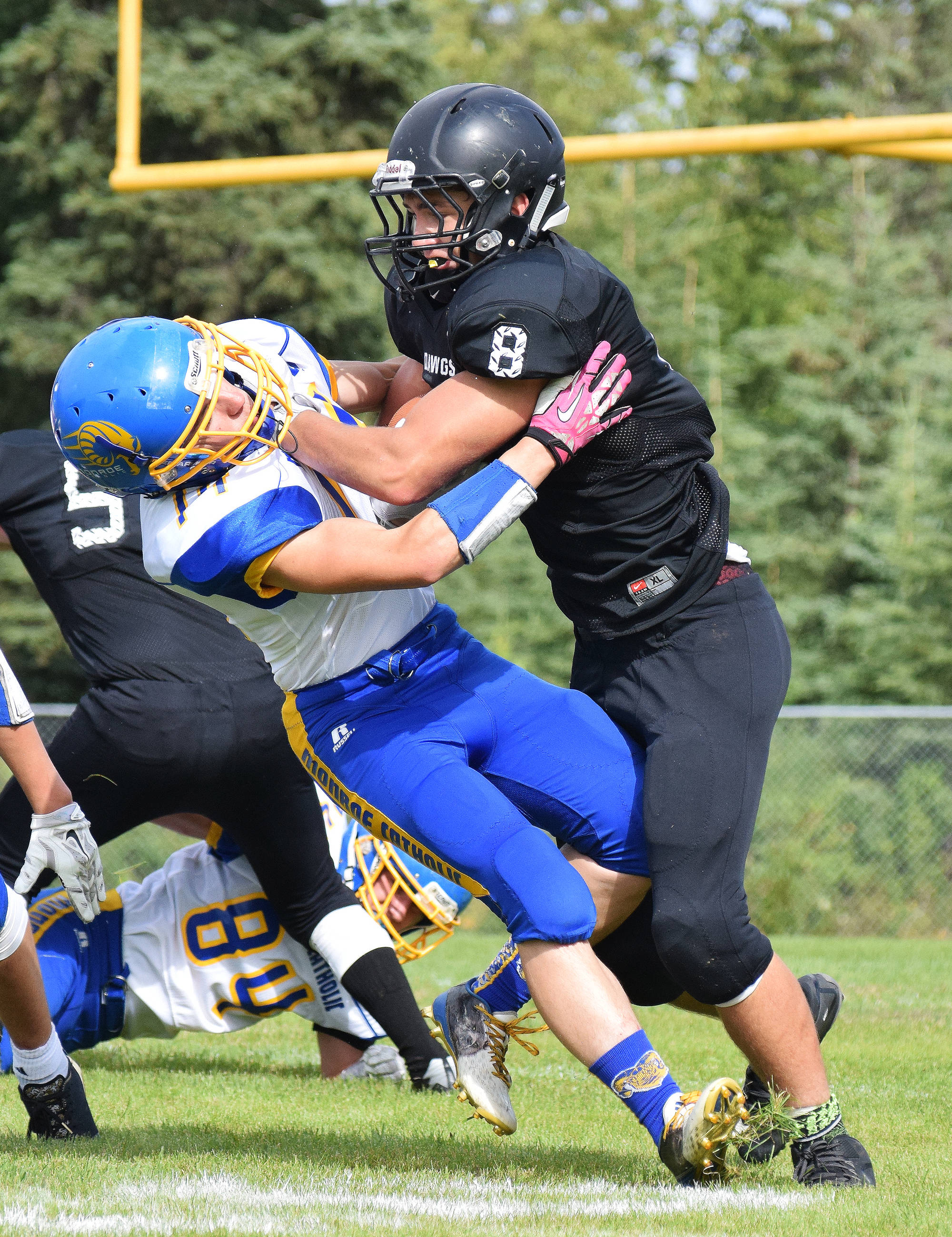 Nikiski senior Ian Johnson (8) sheds Monroe Catholic defensive back Parker Glaves in the third quarter of Saturday’s Division III game at Nikiski High School. (Photo by Joey Klecka/Peninsula Clarion)
