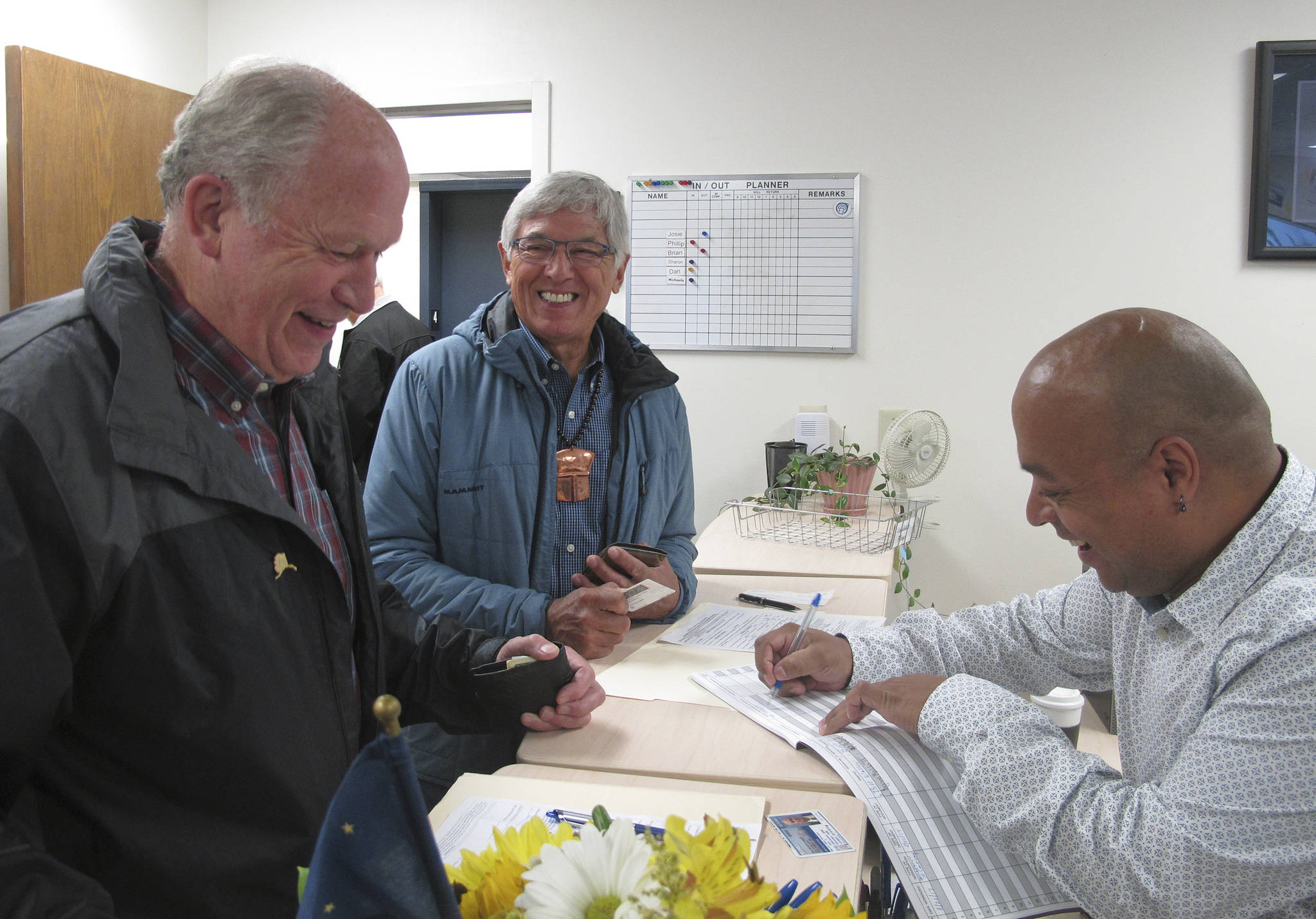 Gov. Bill Walker, left, and Lt. Gov. Byron Mallott, center, smile as they complete paperwork at the state Division of Elections on Monday in Juneau. Walker and Mallott announced plans to seek re-election on Monday. (AP Photo/Becky Bohrer)