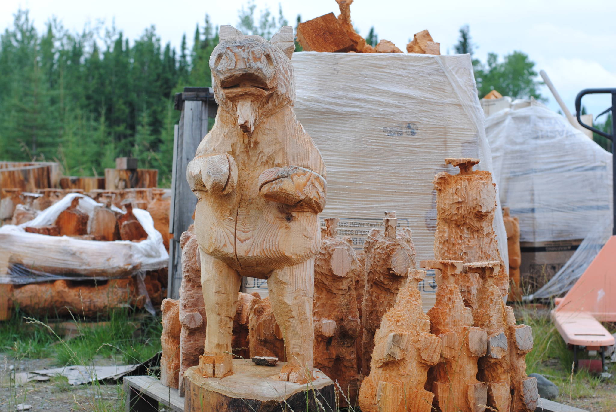 Eric Berson’s chainsaw carvings stand tall, waiting for the finishing touches at his shop in Sterling.