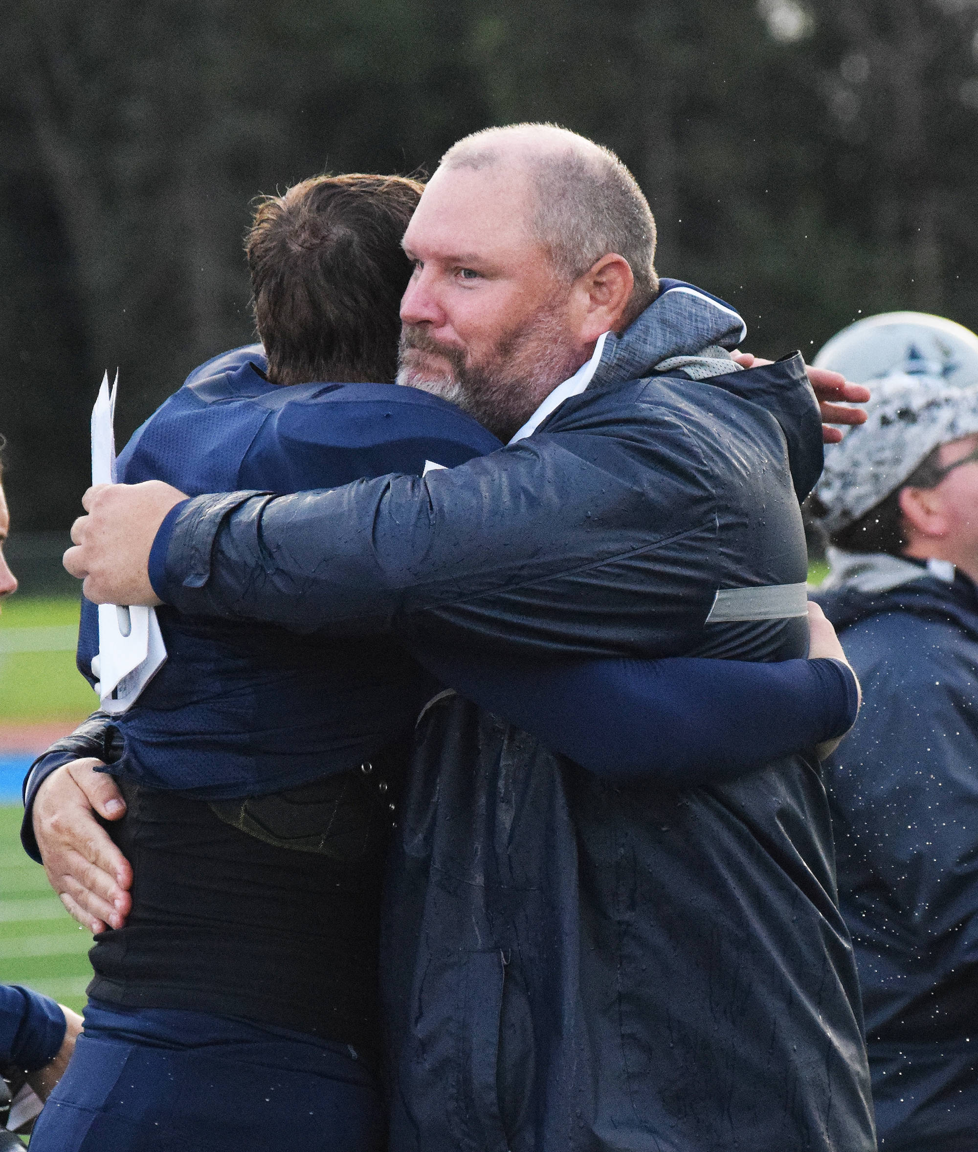 Soldotna head football coach Galen Brantley Jr. hugs senior quarterback Brandon Crowder after Friday night’s 52-7 win over South Anchorage at Justin Maile Field in Soldotna. The win was the 100th in Brantley Jr.’s coaching career. (Photo by Joey Klecka/Peninsula Clarion)