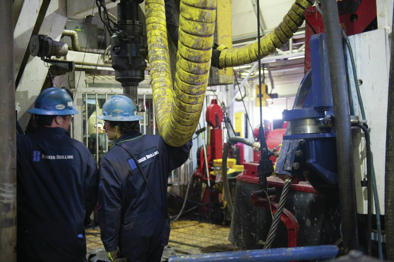 A pair of crew members work on the drilling deck of Parker Rig 272 at Prudhoe Bay in May. The oil industry has lost 25 percent of its jobs since hitting a peak in 2015, with about 3,600 jobs lost over the past two years. (Photo/Michael Dinneen/For the Journal)